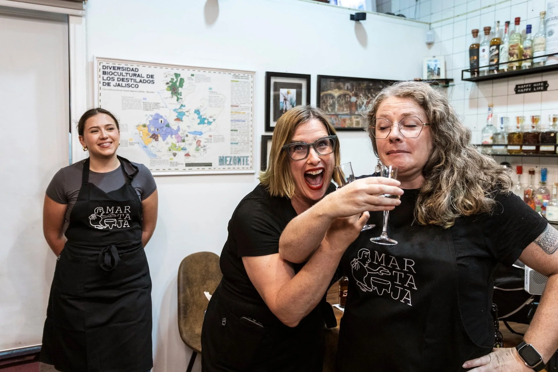 Happy guests enjoying a tequila tasting as part of their Martaja mole and tamales cooking class