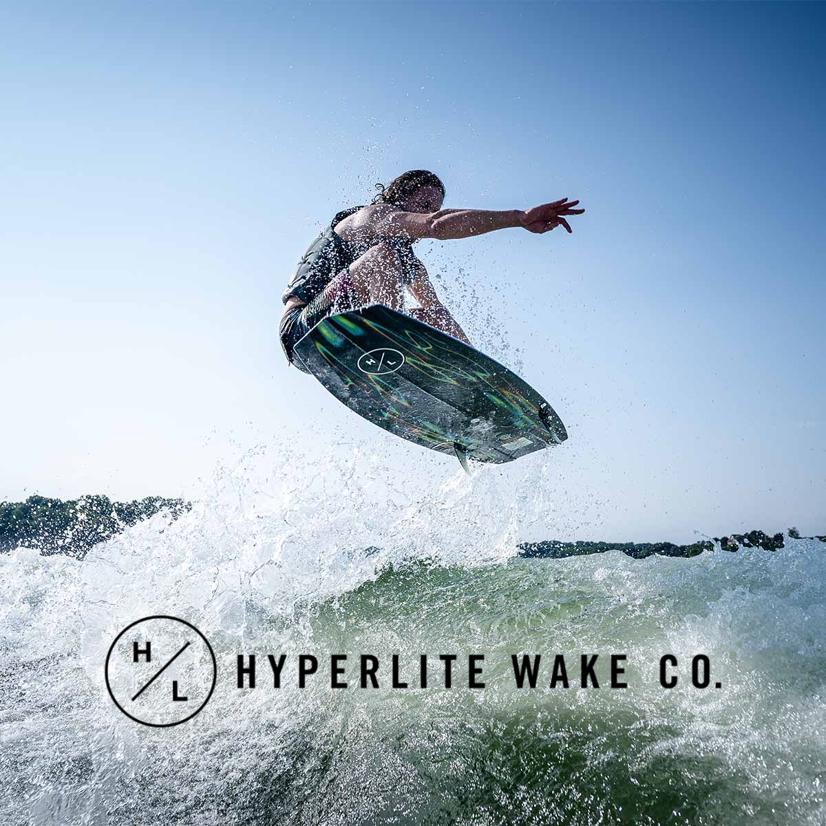 A person surfing on a wave in the ocean during daytime, with the logo and name 'Hyperlite Wake Co.' at the bottom.