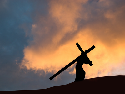 jesus carrying cross up a hill