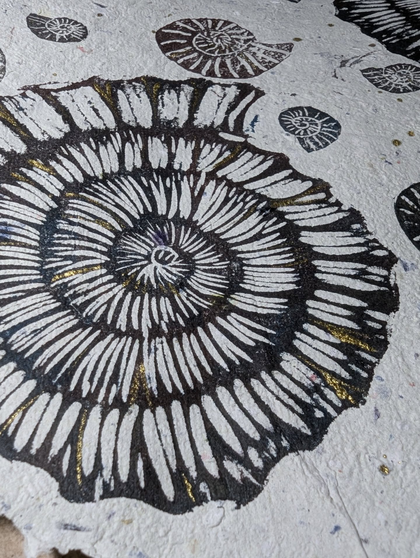 Playing with texture today with handmade paper, a lino block I carved last year and some new mini rubber stamps I carved this morning. 

The inspiration/brief was "stone" and I immediately got a picture of ammonites nestling together on a s