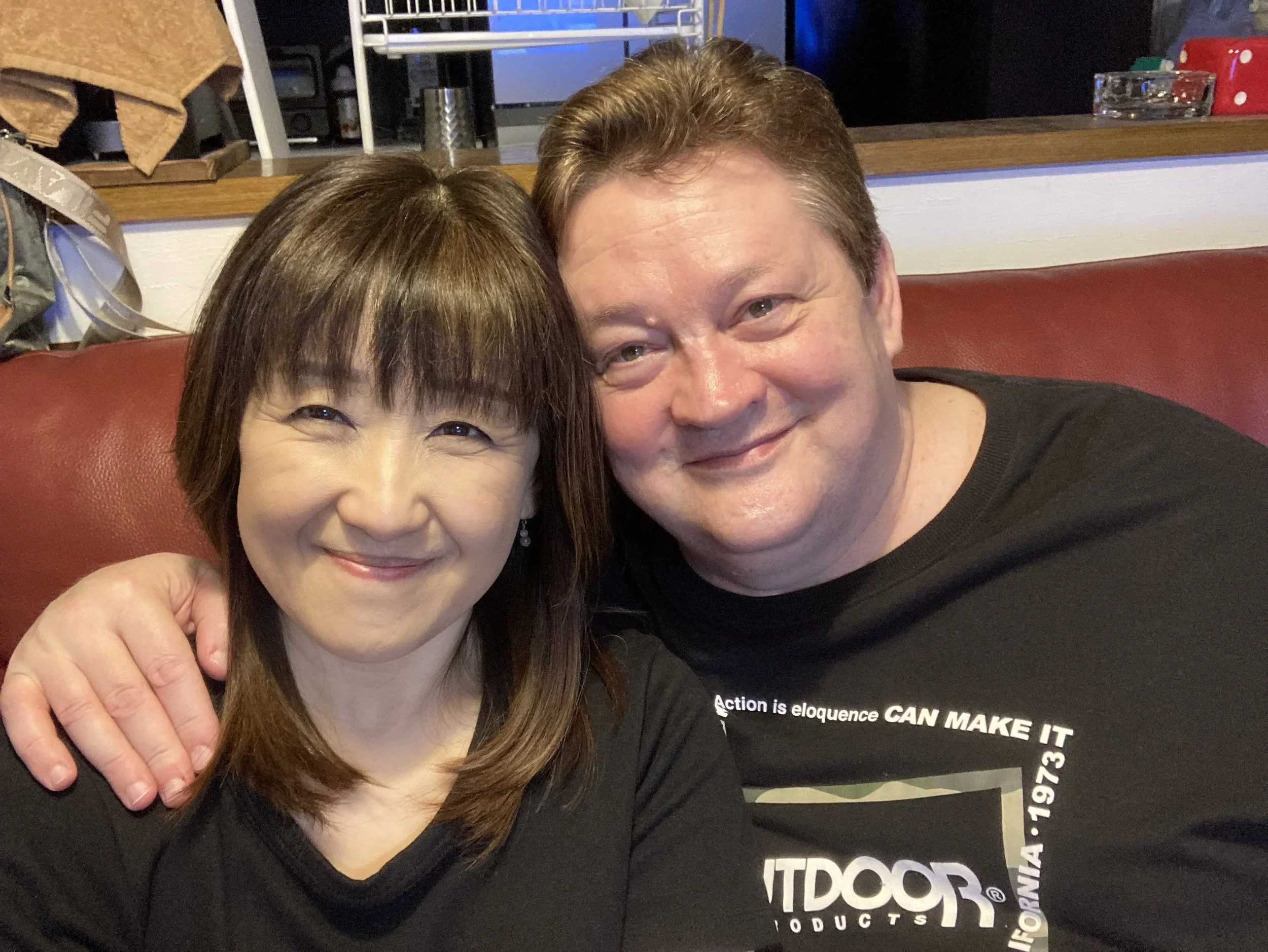 Husband and wife smiling together, seated closely, representing the personal partnership behind Kamui Vintage.