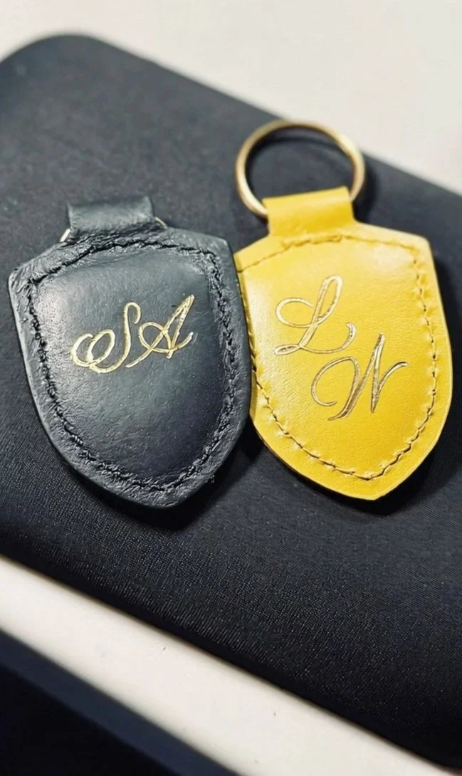two key tags, one black and one yellow, personalized with hot foiling technique using gold foil