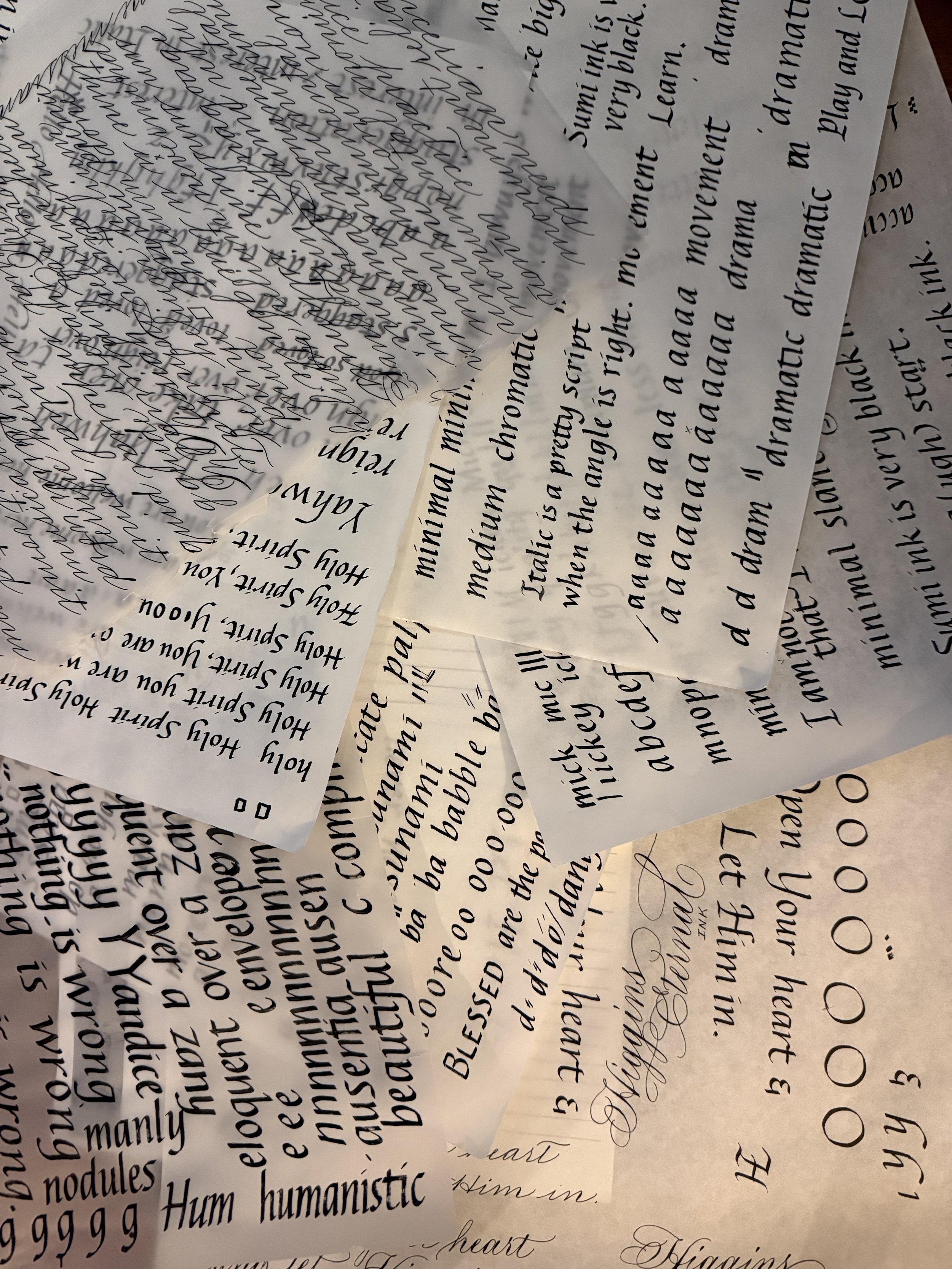 italic and other scripts written on multiple pieces of tracing paper as practice sheets