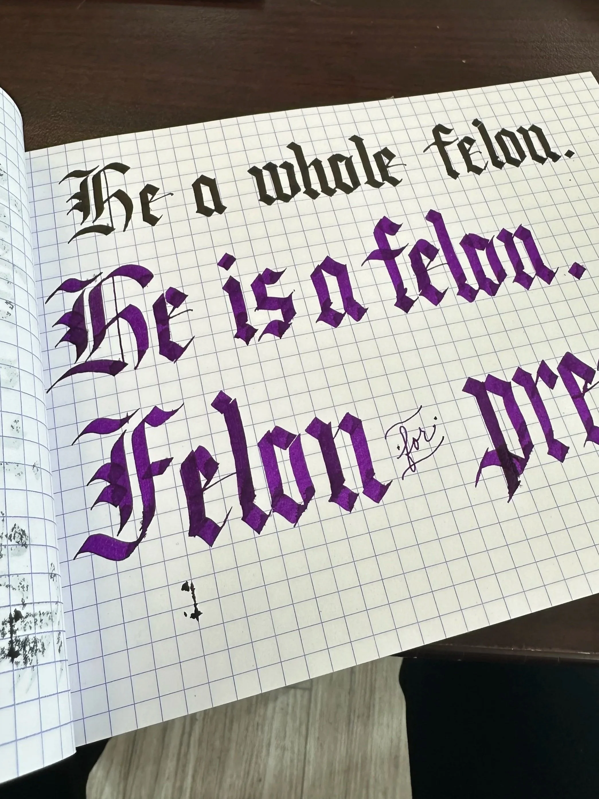 black and purple blackletter written on gridded notebook paper