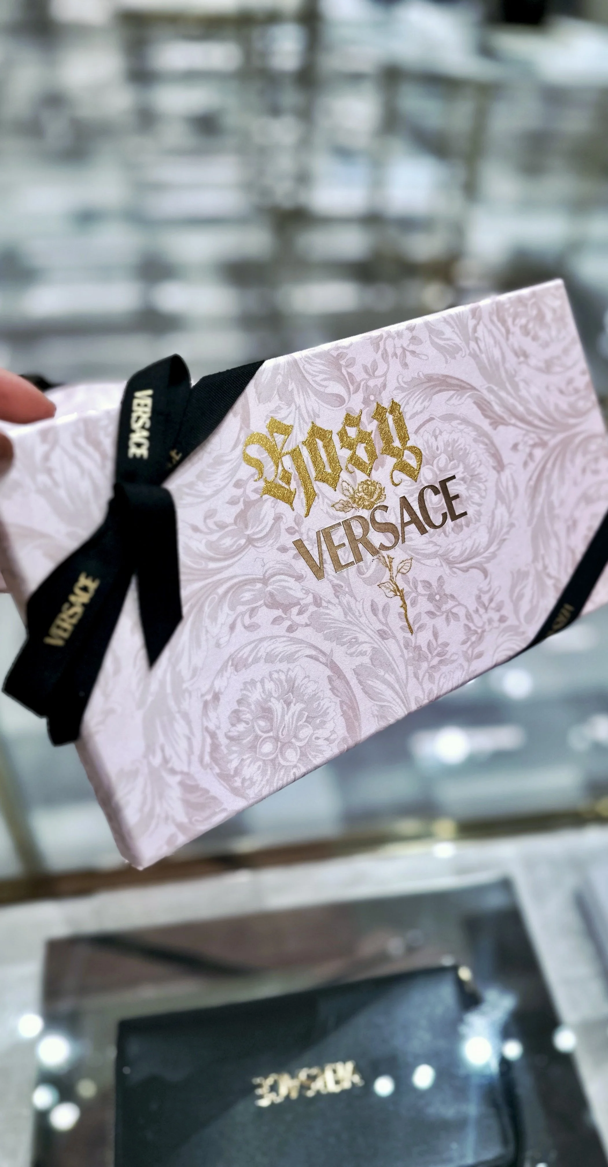 versace box with Rosy written in blackletter and a handdrawn rose in gold