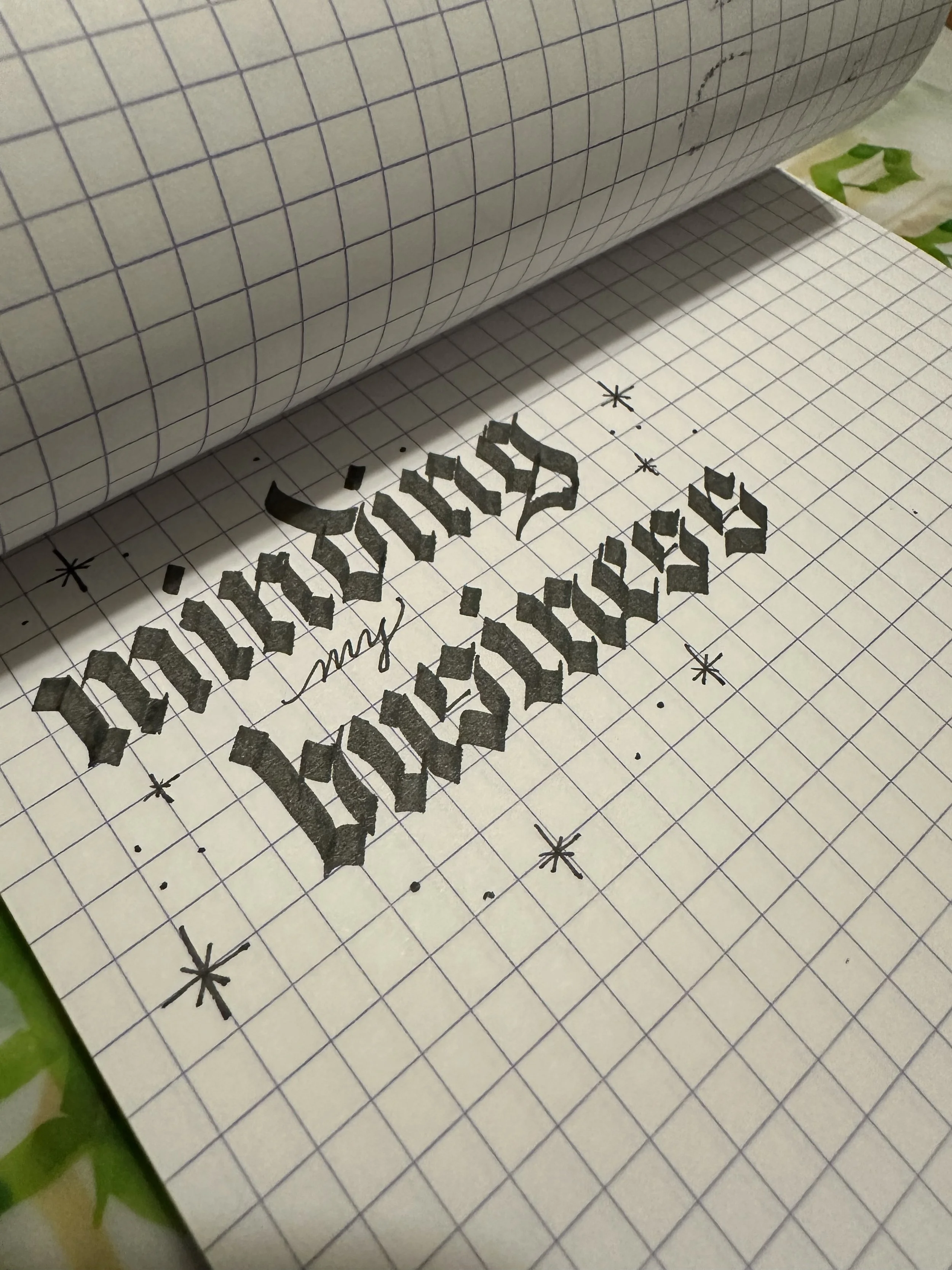 minding my business written in blackletter on gridded notebook