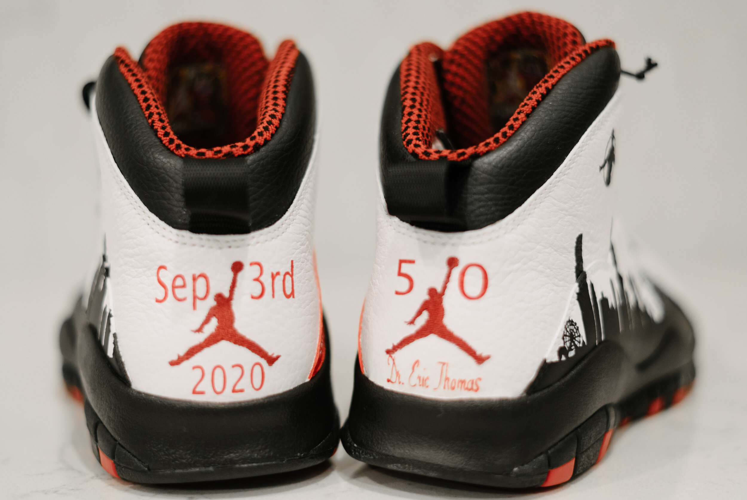 Pair of customized white and black Nike Air Jordan sneakers with red accents, featuring personal and commemorative details for a race event on September 3rd, 2020, with the inscriptions 'Sep 3rd 2020' and '5/0', along with signatures and skyline grap