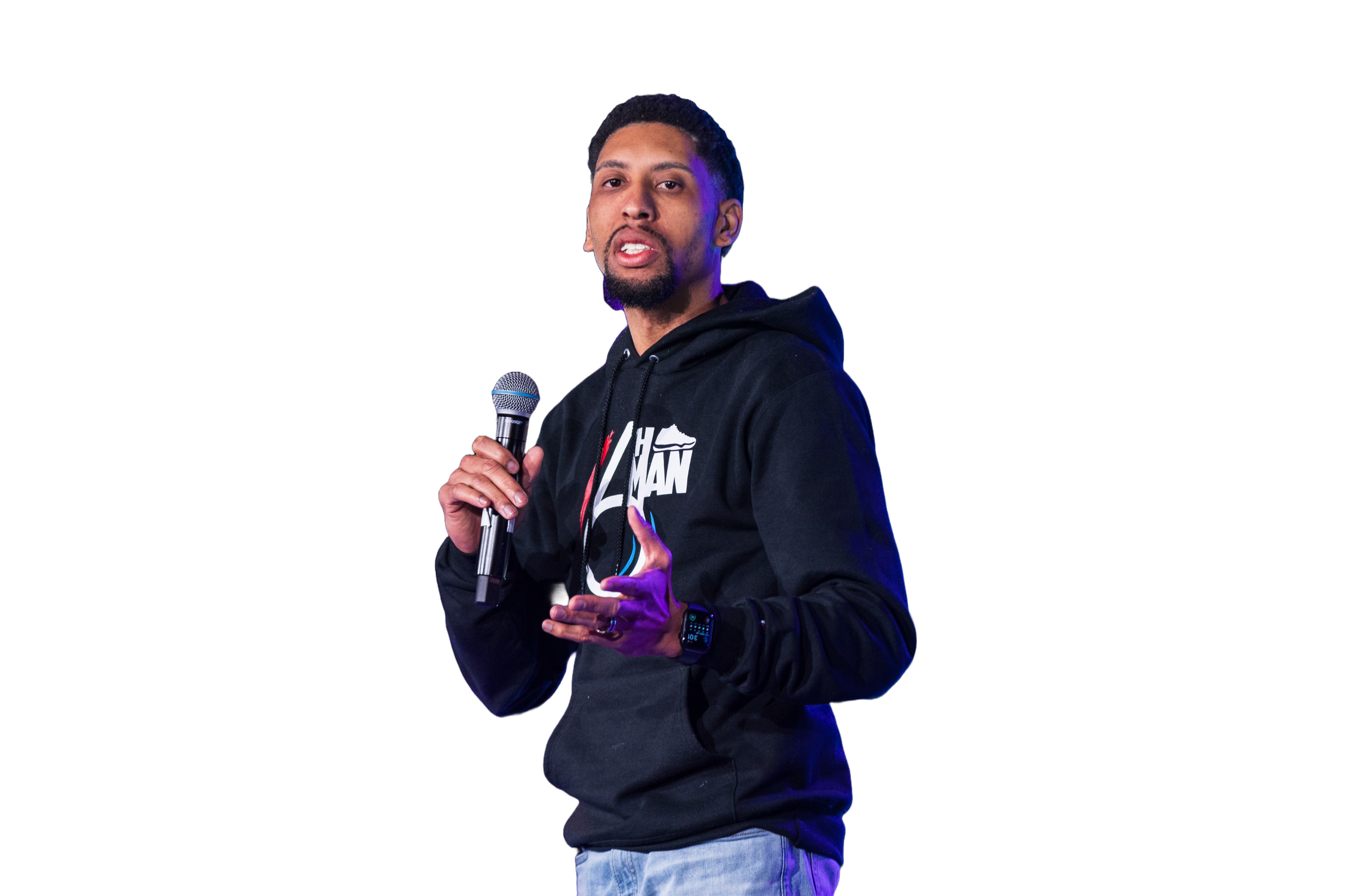 Man holding microphone and wearing a black hoodie with a graphic design, standing against a background with red and black stripes.