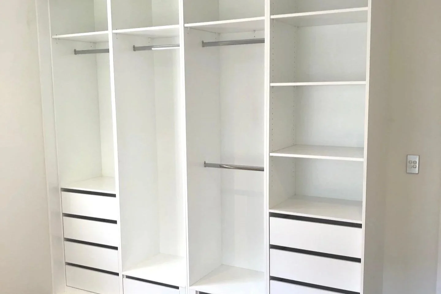 Empty white wardrobe with open shelves and drawers