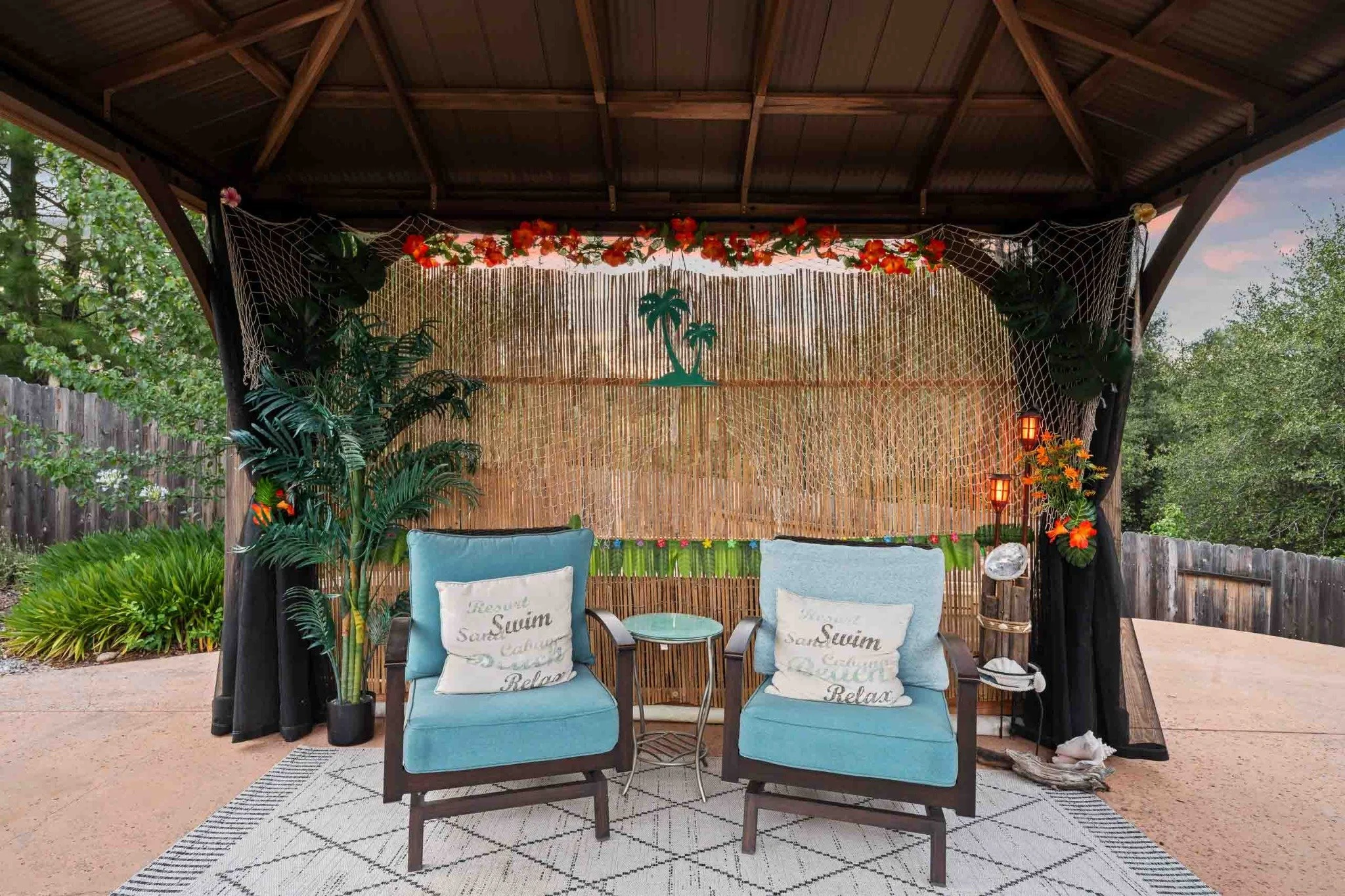 Covered outdoor patio with cushioned seating and tropical decor at a Redding-area home.