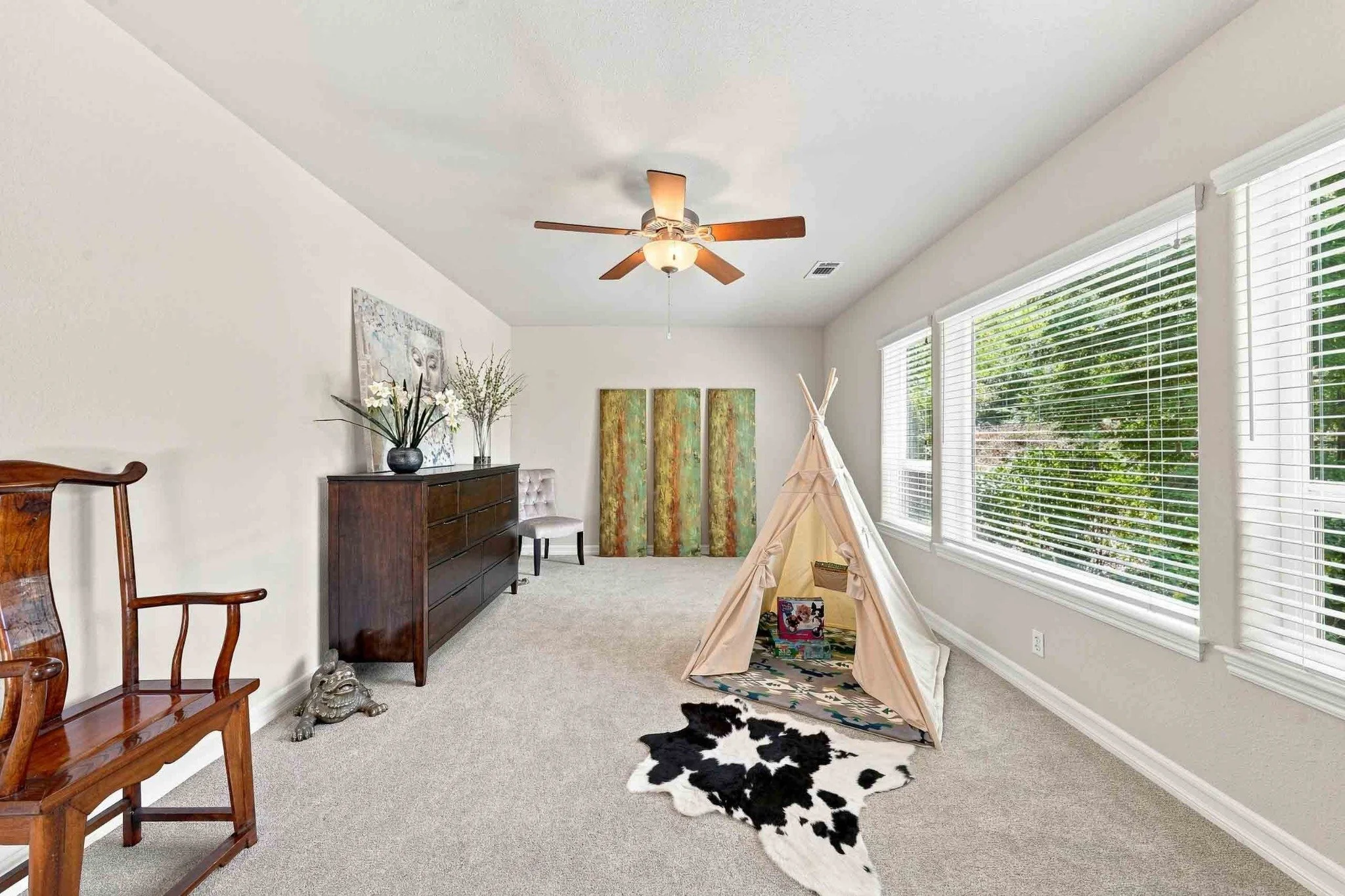 Bright bonus room or playroom with large windows, a ceiling fan, carpet, and a children's play tent.