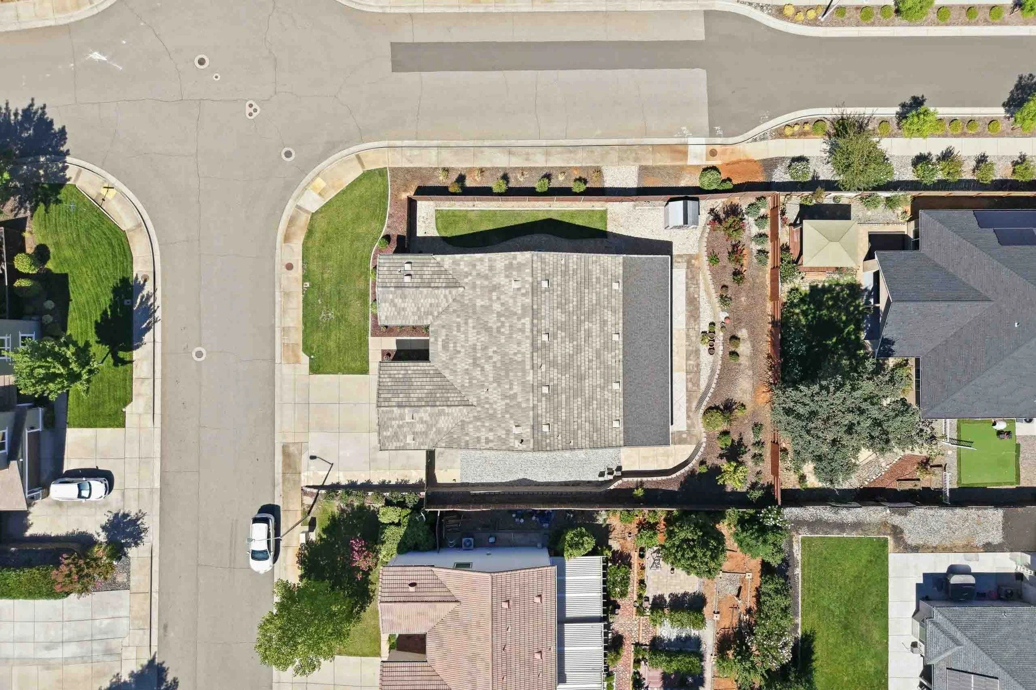Top-down drone view of a corner-lot home and surrounding landscaping in Redding, California.