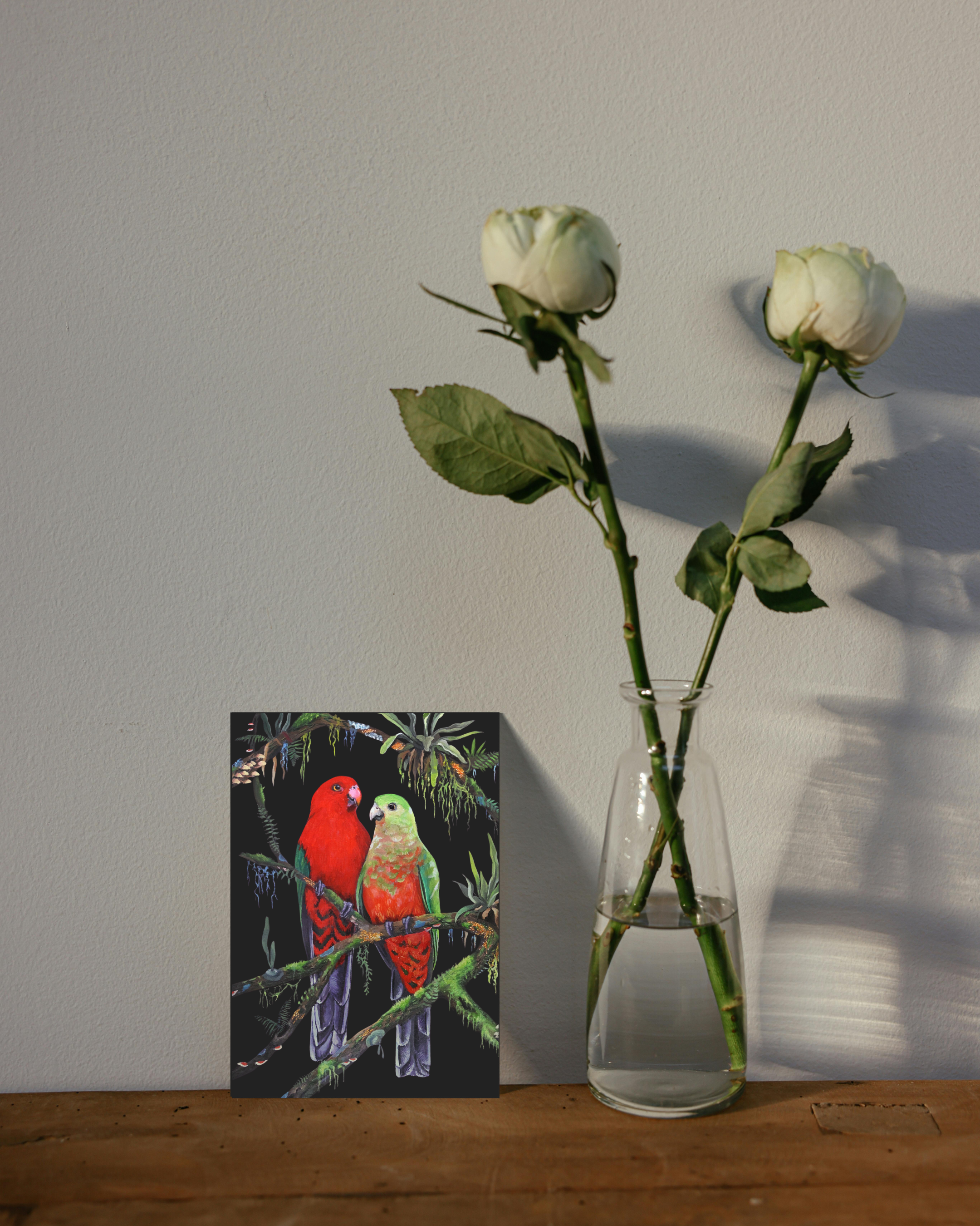 The Canopy Companions King parrots bird wildlife painting greeting card next to flowers.