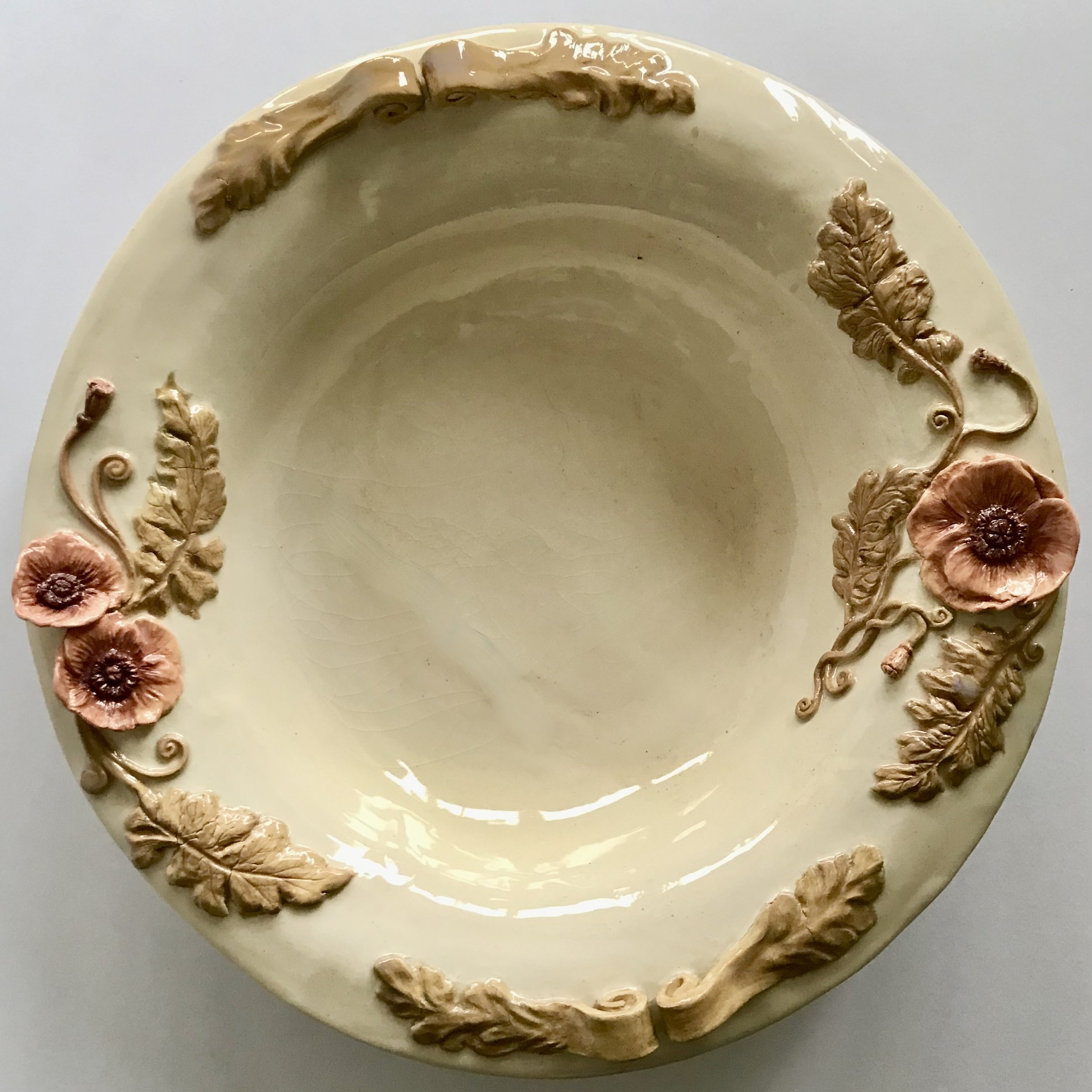 Large Cornish stoneware poppy platter featuring delicately hand sculpted poppies, pods and scrolling foliage, painted in a dusty rose red and an old olive green.