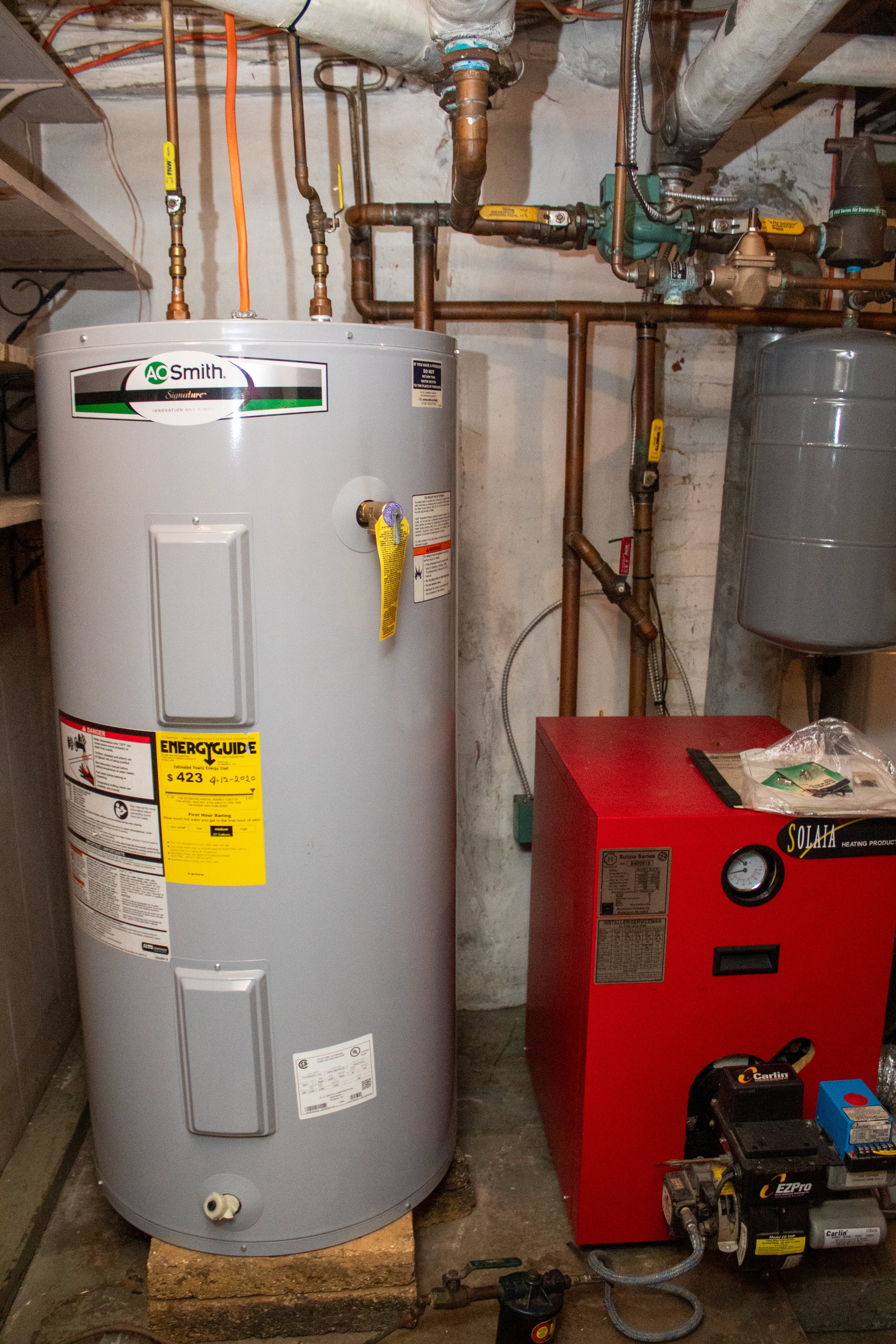 Basement with water heater, boiler, and pipes