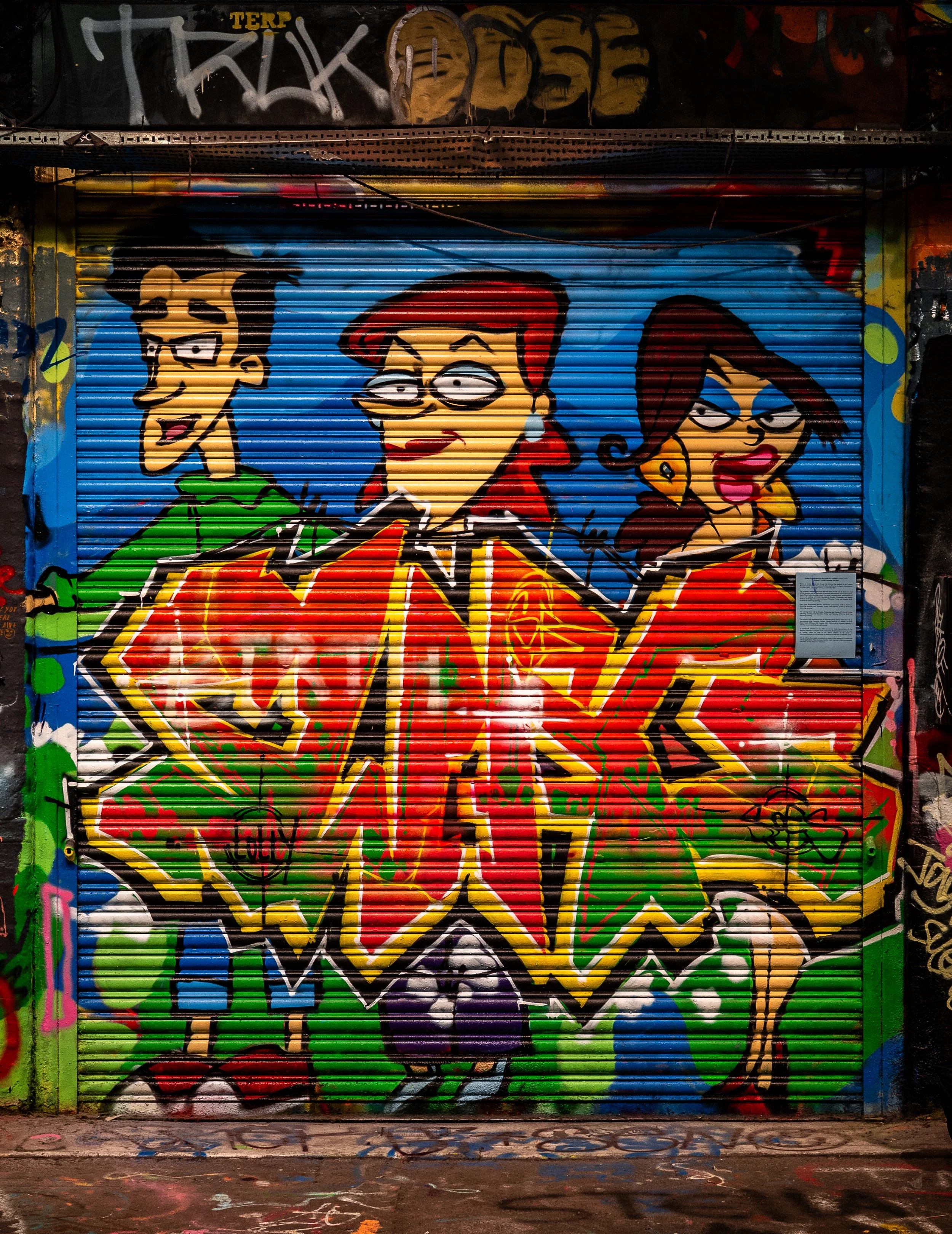 Colorful graffiti mural on a metal rolling door featuring three animated characters with exaggerated features, vibrant clothing, and a bright background.