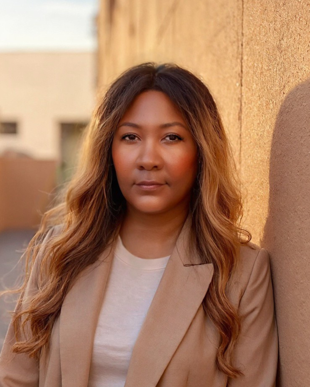 Geneèn Wright, workforce anthropologist and founder of Career Communiqué, standing outdoors in a tan blazer at golden hour, looking directly at the camera with a composed and thoughtful expression.