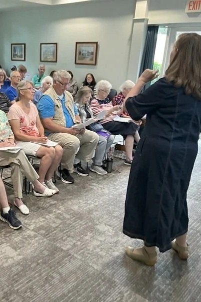 Cath addresses a group in a seminar setting