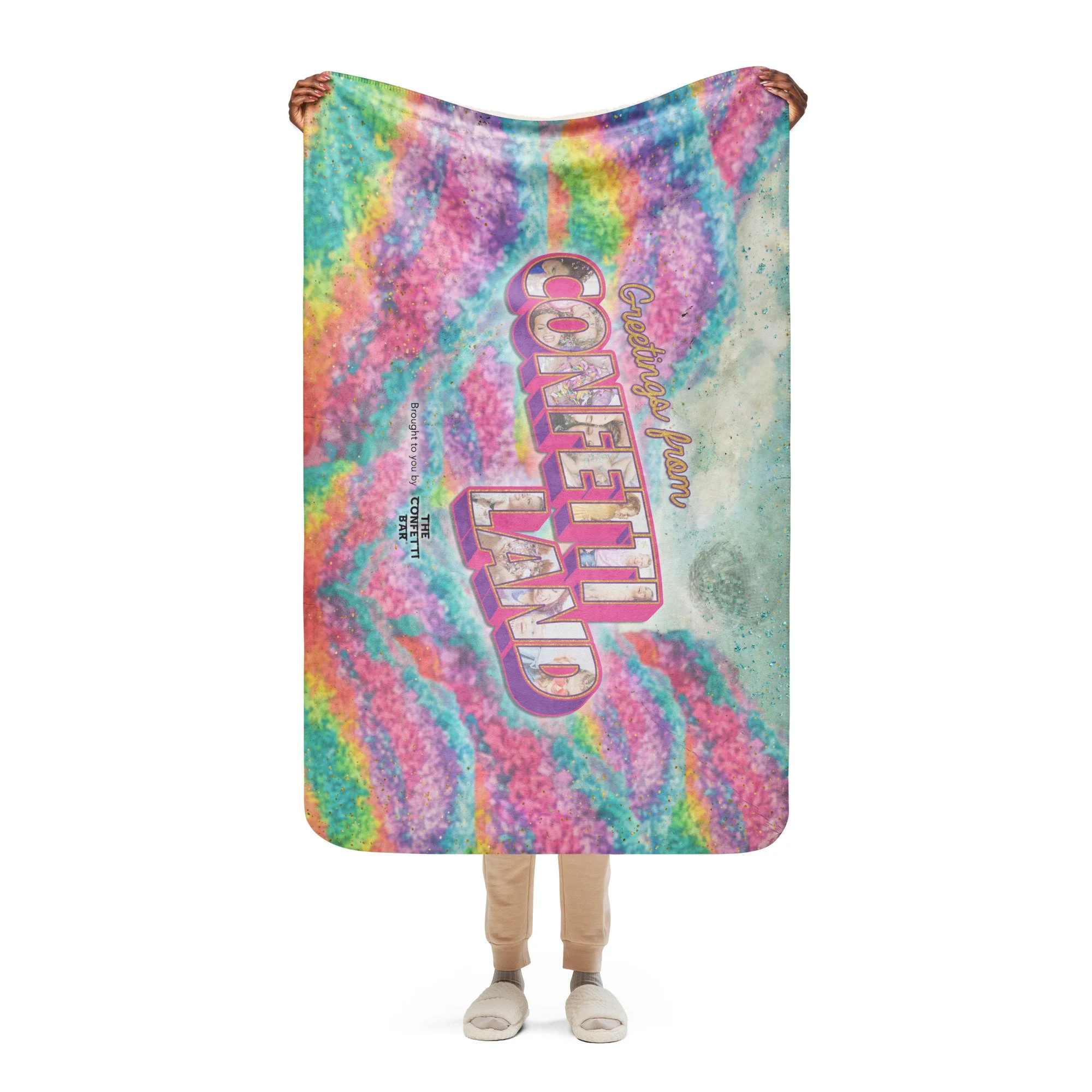 Person holding a colorful rainbow tie-dye themed blanket or towel with the words "Friendship fan CONFECTION LAND" and other smaller text and graphics on it.
