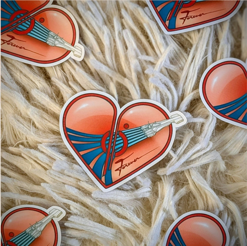 A sticker of a heart with a starcruiser illustration and the word "Forever" written underneath, . the stickers are on a furry white surface