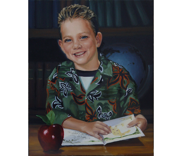 A young boy with short, light brown hair is smiling and sitting at a wooden table. He is wearing a green Hawaiian shirt with red, black, and white floral patterns. In front of him, there is an open book and a large red apple. Behind him, there are bookshelves and a globe.