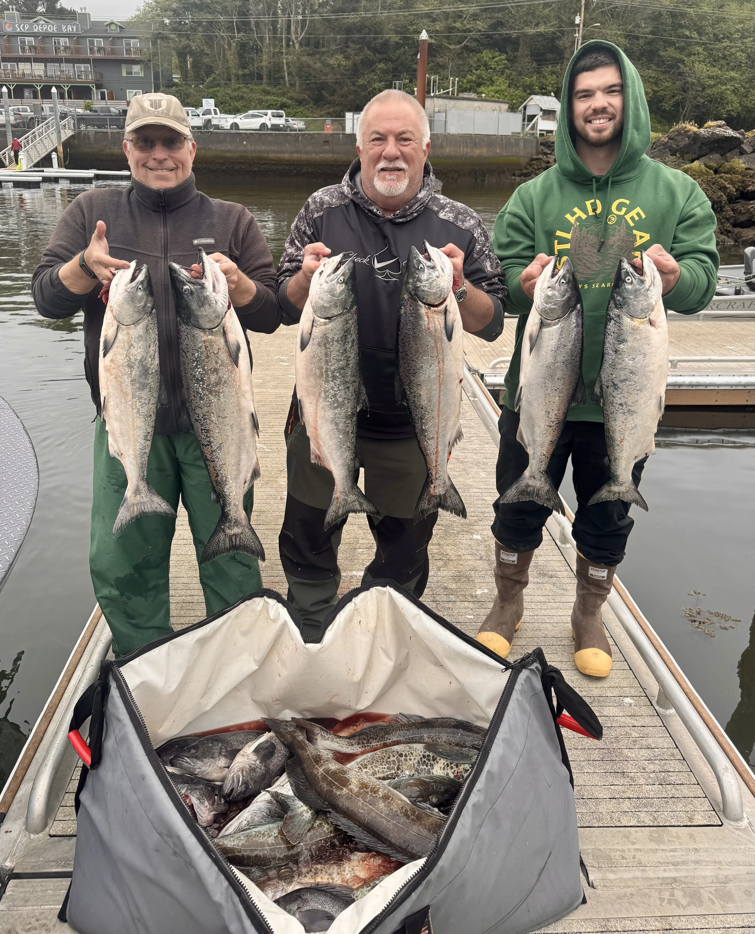 Group of 3 men holding a limit of Chinook salmon, lingcod and rockfish after going on a charter trip with Mitchell Brooks out of Depoe Bay.