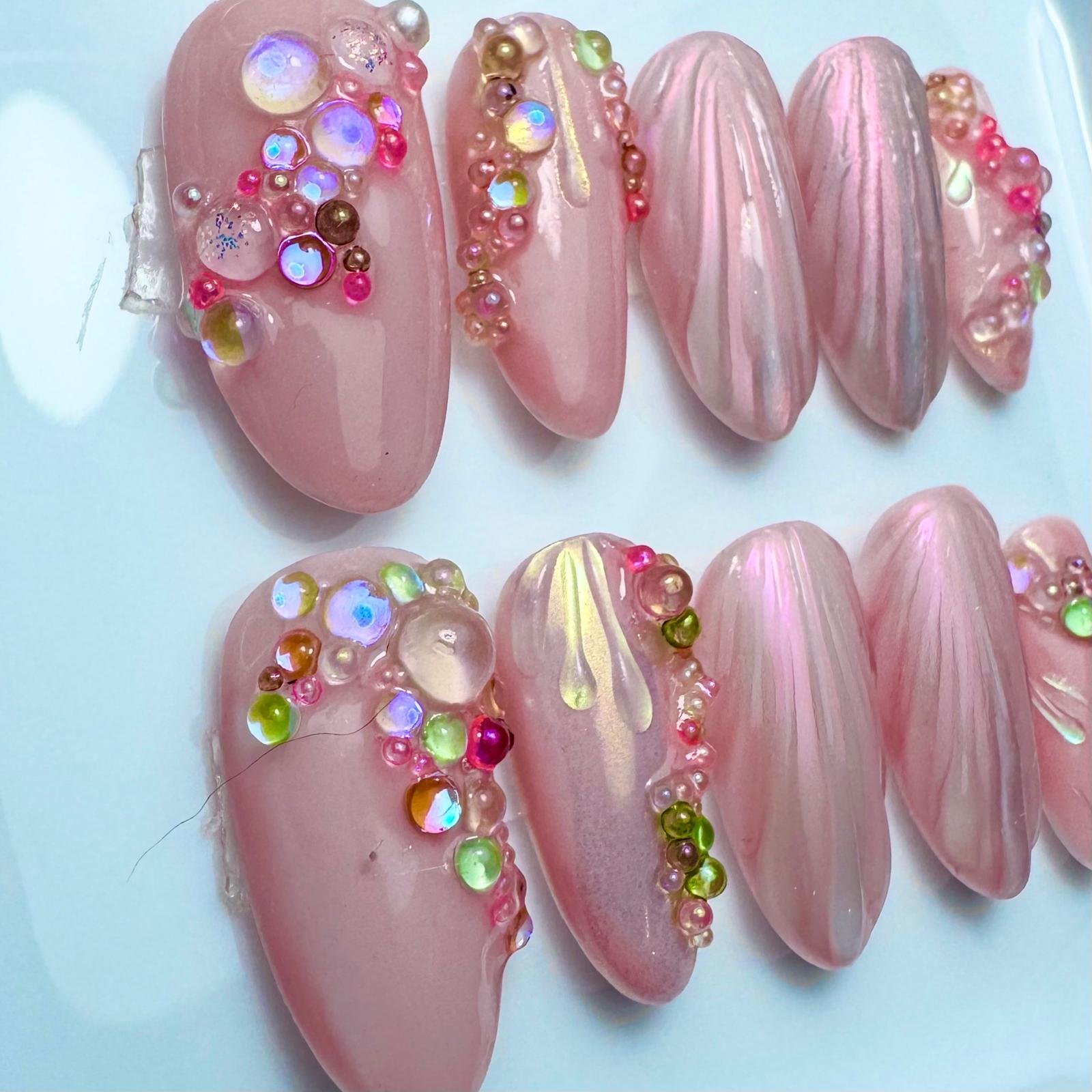 Press on nagels in een naturel roze tint met een schelpjes patroon en bloemen gevormd door parels