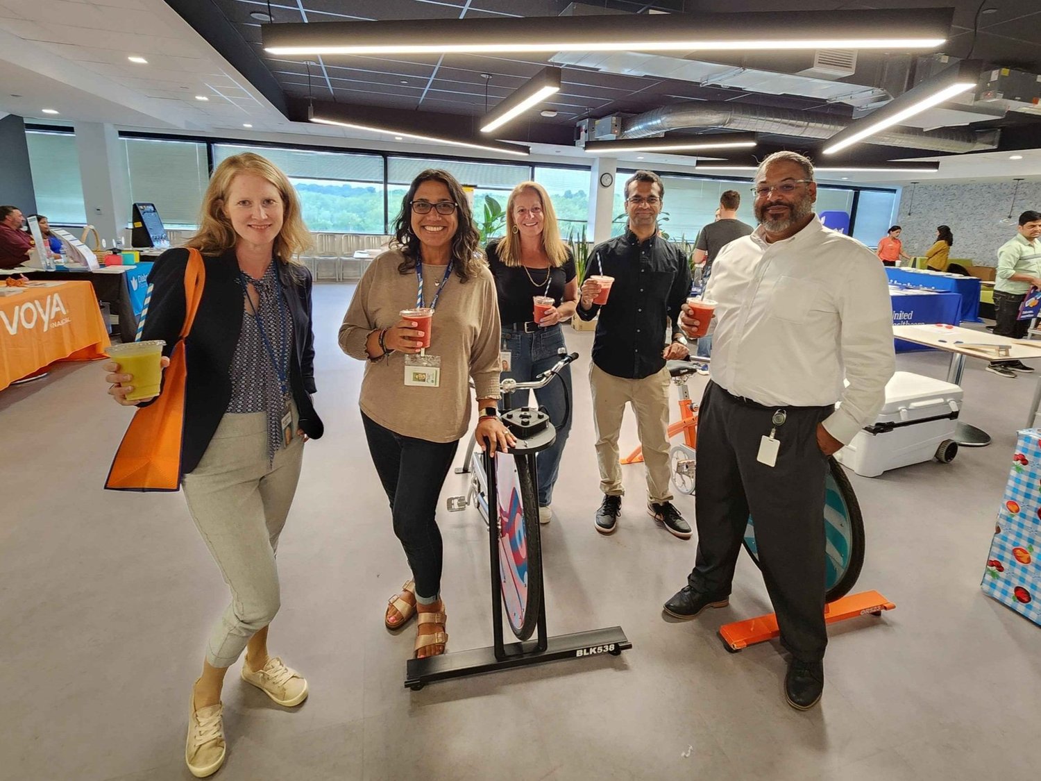 Team holding fresh smoothies (Voya)