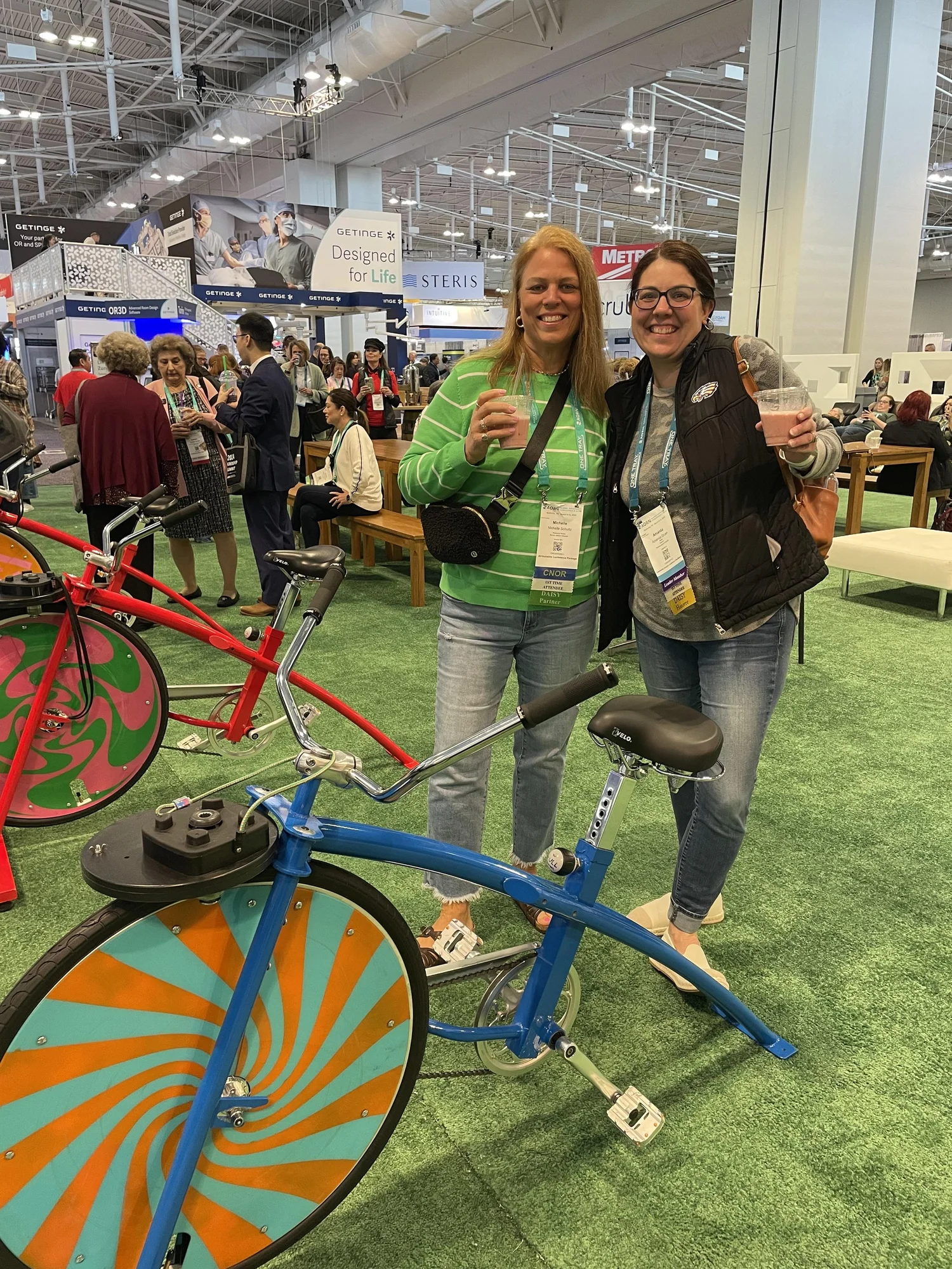 Guests holding fresh smoothies beside colorful bikes at an event