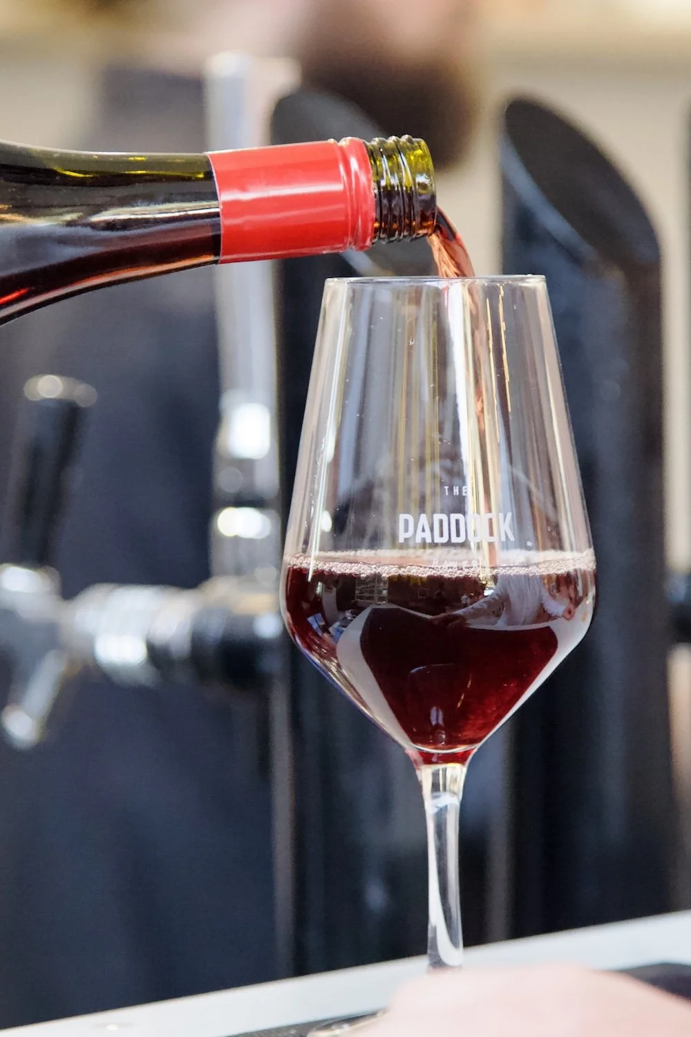Bottle of red wine being poured into "The Paddock" glass for event at Paddock Bakery Geelong, perfect for private functions and celebrations. 