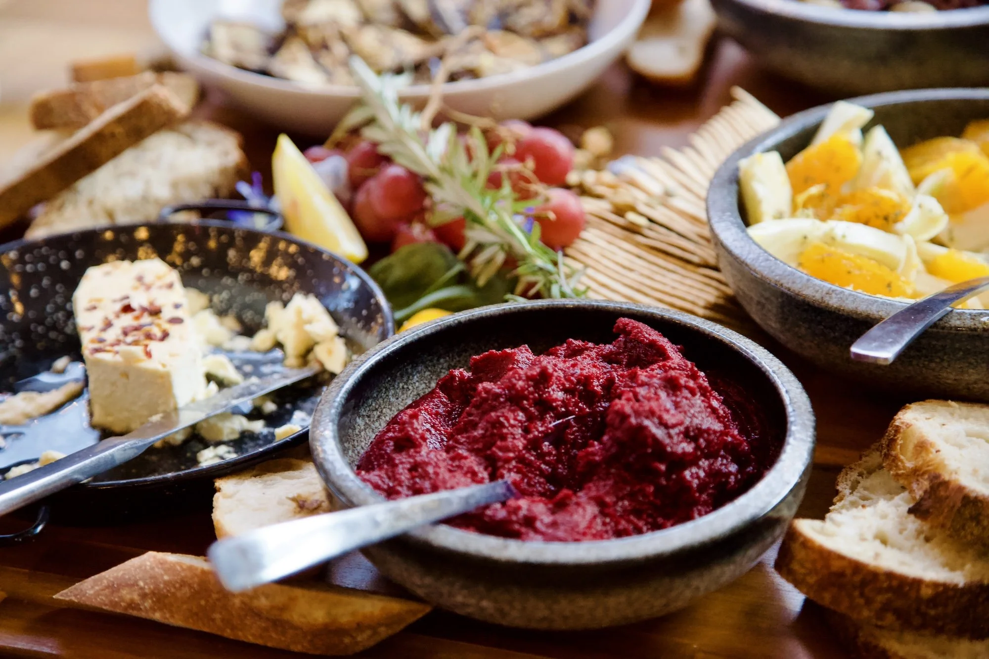 Colourful grazing table at Paddock Bakery Geelong with beet hummus, cheese, eggs, and fresh produce.
