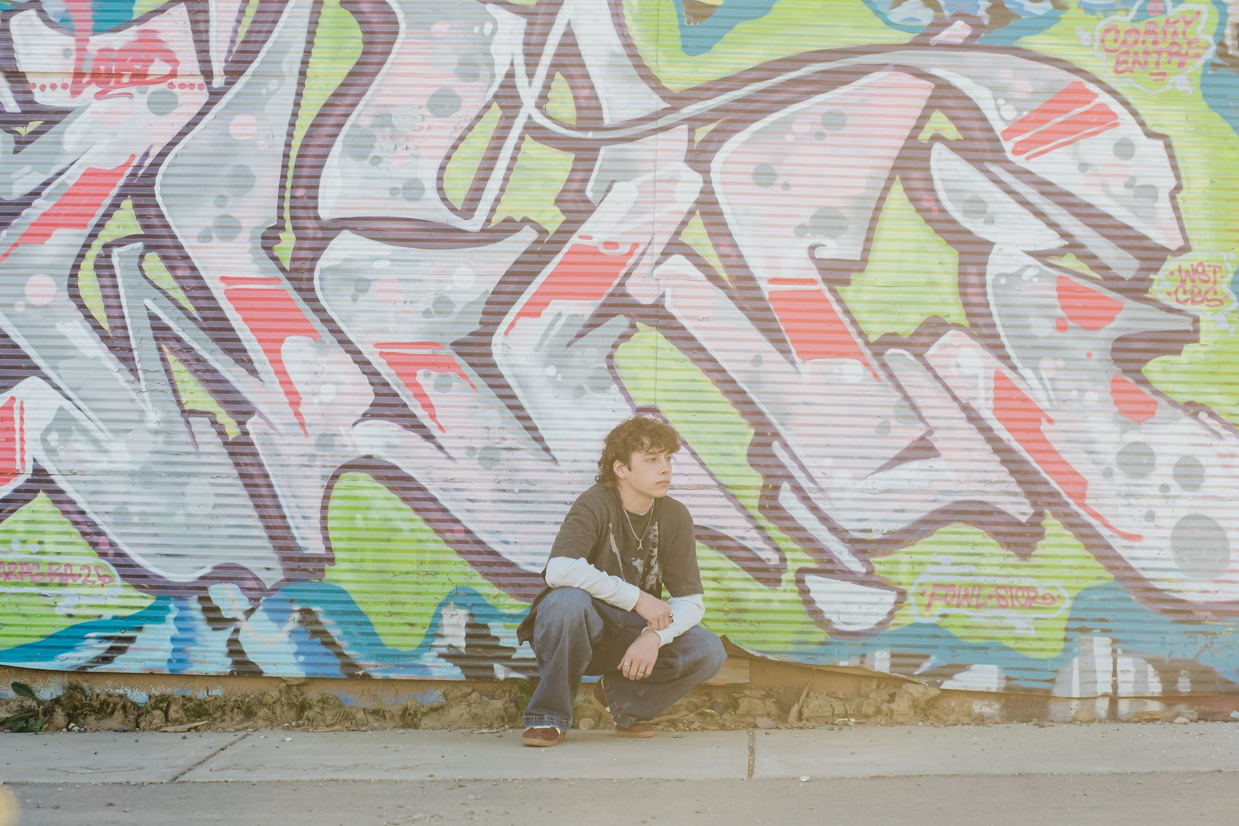 highschool senior boy in front of graffiti wall Asheville North Carolina