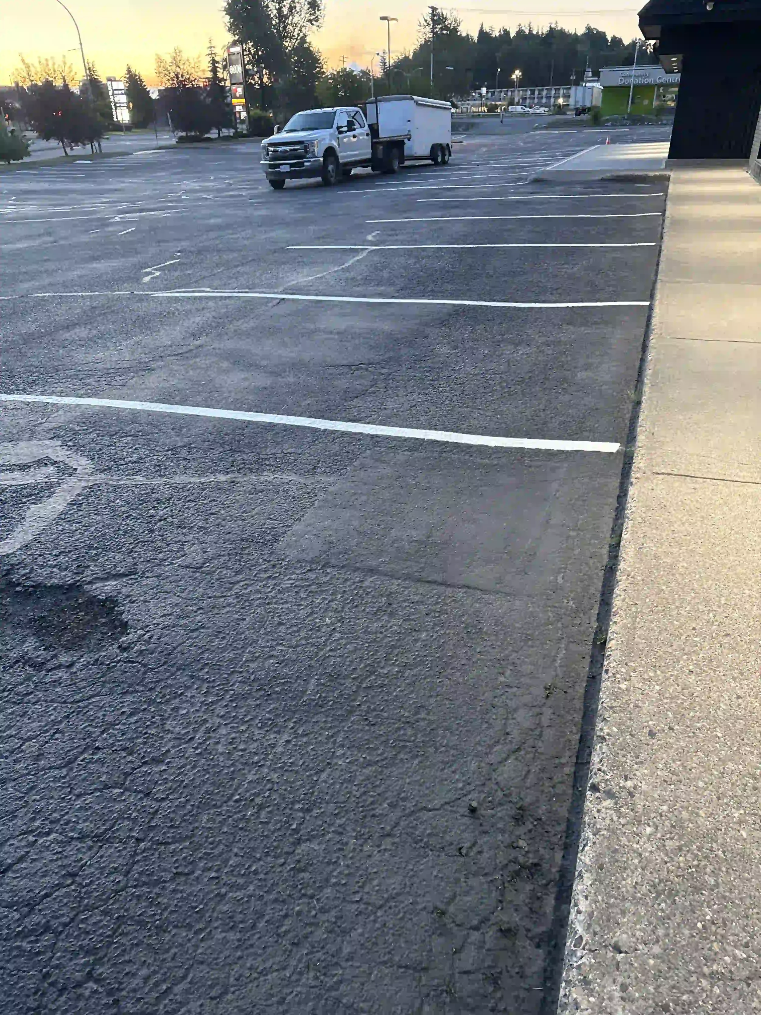Freshly painted white storefront parking stall lines in a commercial parking lot following professional line painting services by Epic Pavement.