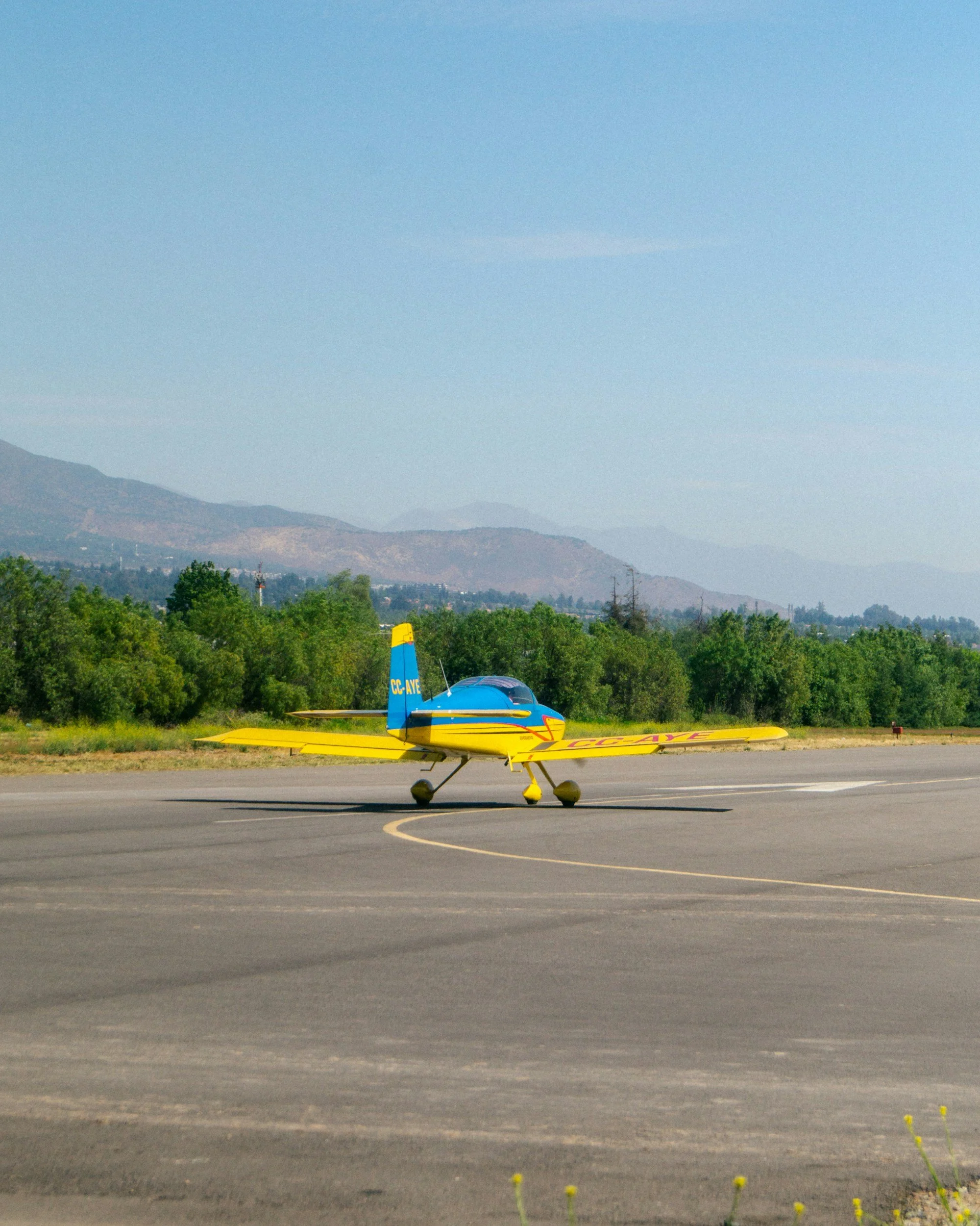 Small aircraft parked on airport apron with visible pavement markings