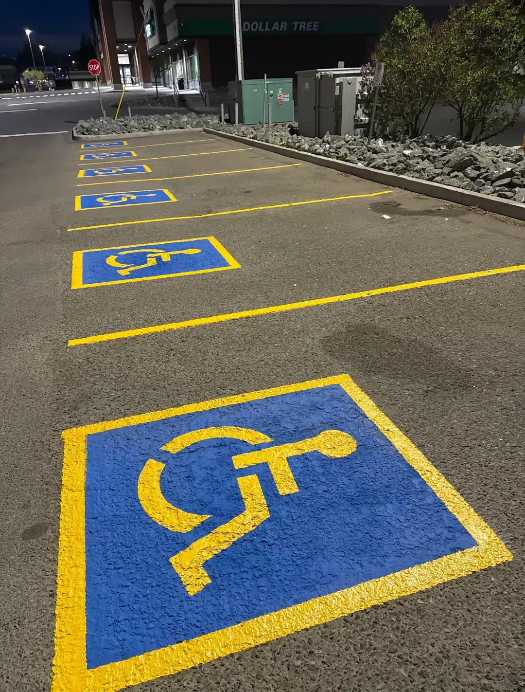Accessible parking space line painting with blue handicap symbols at commercial property - Epic Pavement