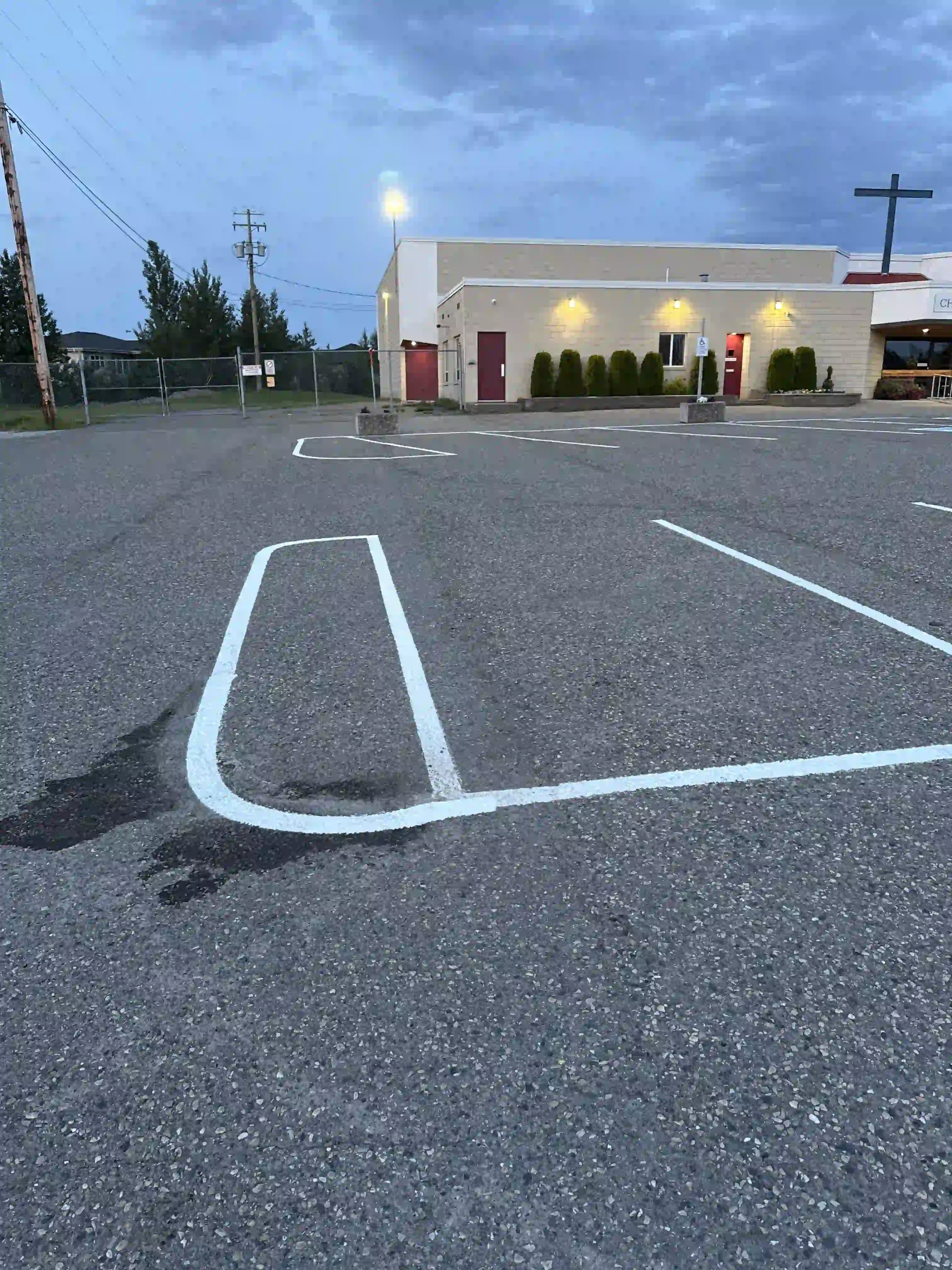 Fresh white parking stall line painting and pavement markings at a church parking lot in Fort St. John, BC