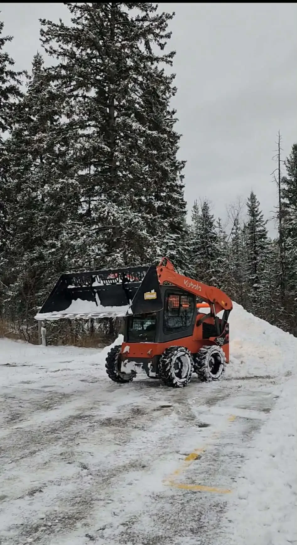 Person operating a  snow removal machine clearing snow outdoors during winter.