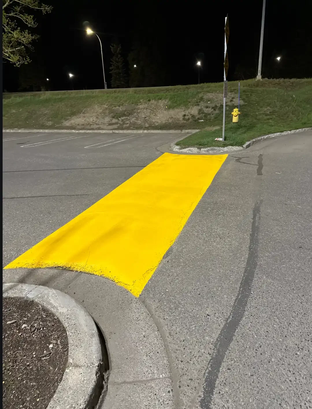 Fresh yellow speed bump marking painted on asphalt at commercial property - Epic Pavement