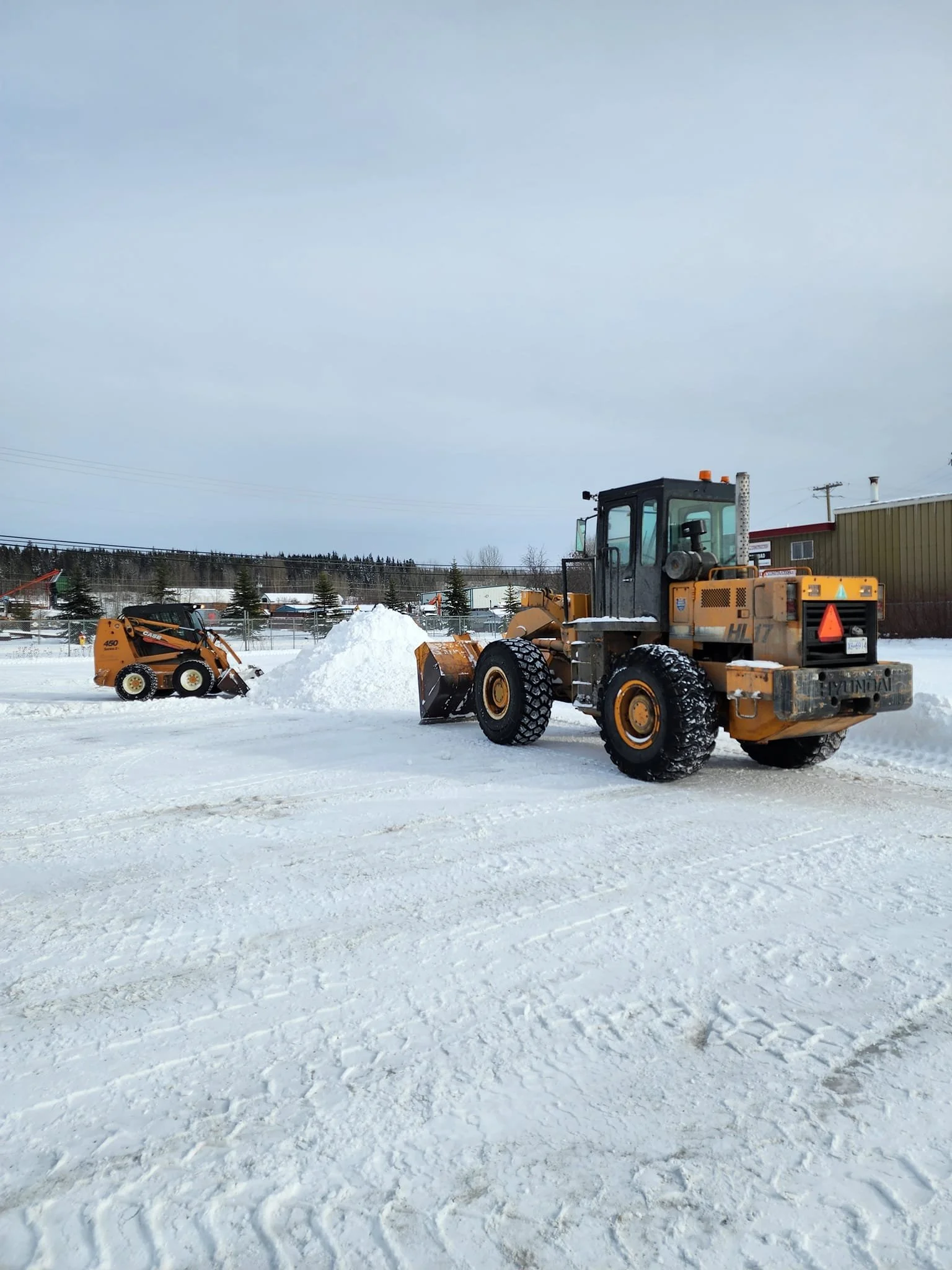 Snow removal equipment clearing snow from a commercial business property in Prince George, BC - Epic Pavement
