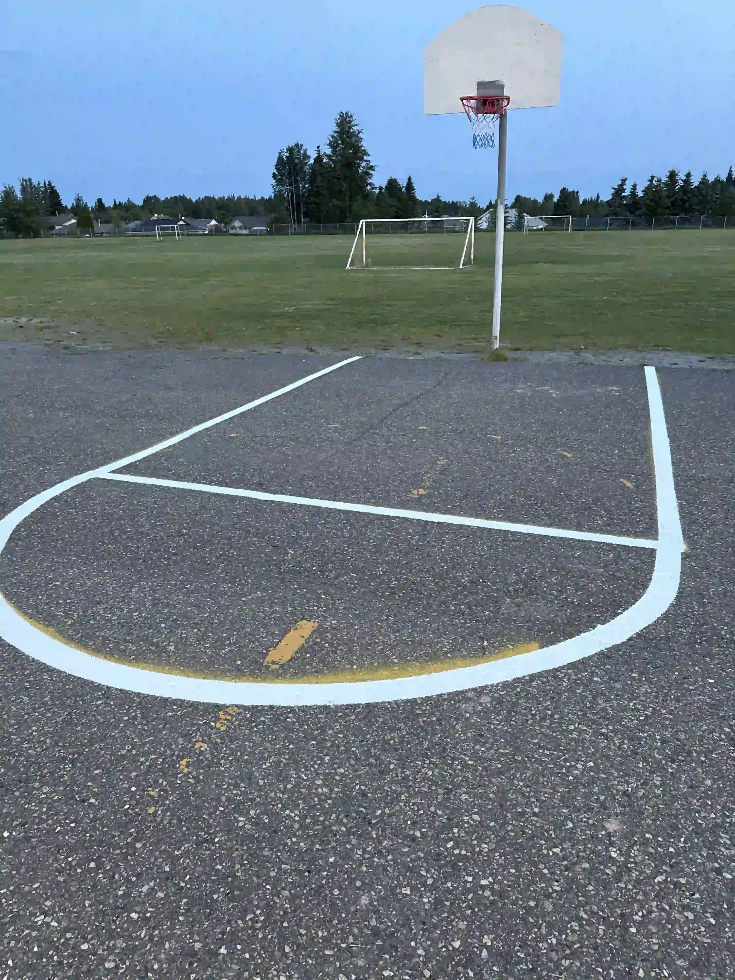 Outdoor sports court line painting and crisp white basketball court markings completed in Kamloops, BC.