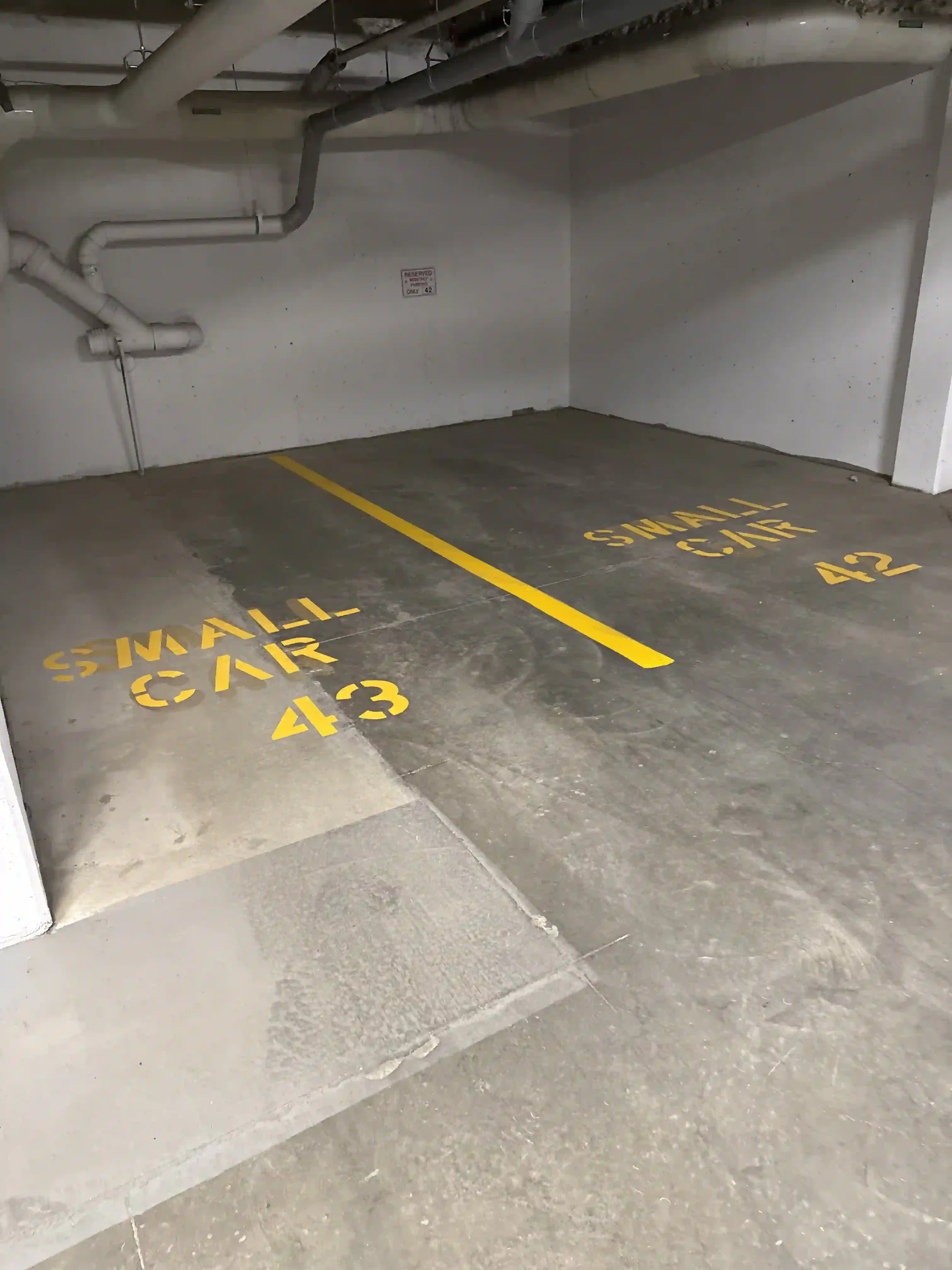 Underground parkade line painting and custom yellow stall markings completed for a commercial property in Kamloops, BC.