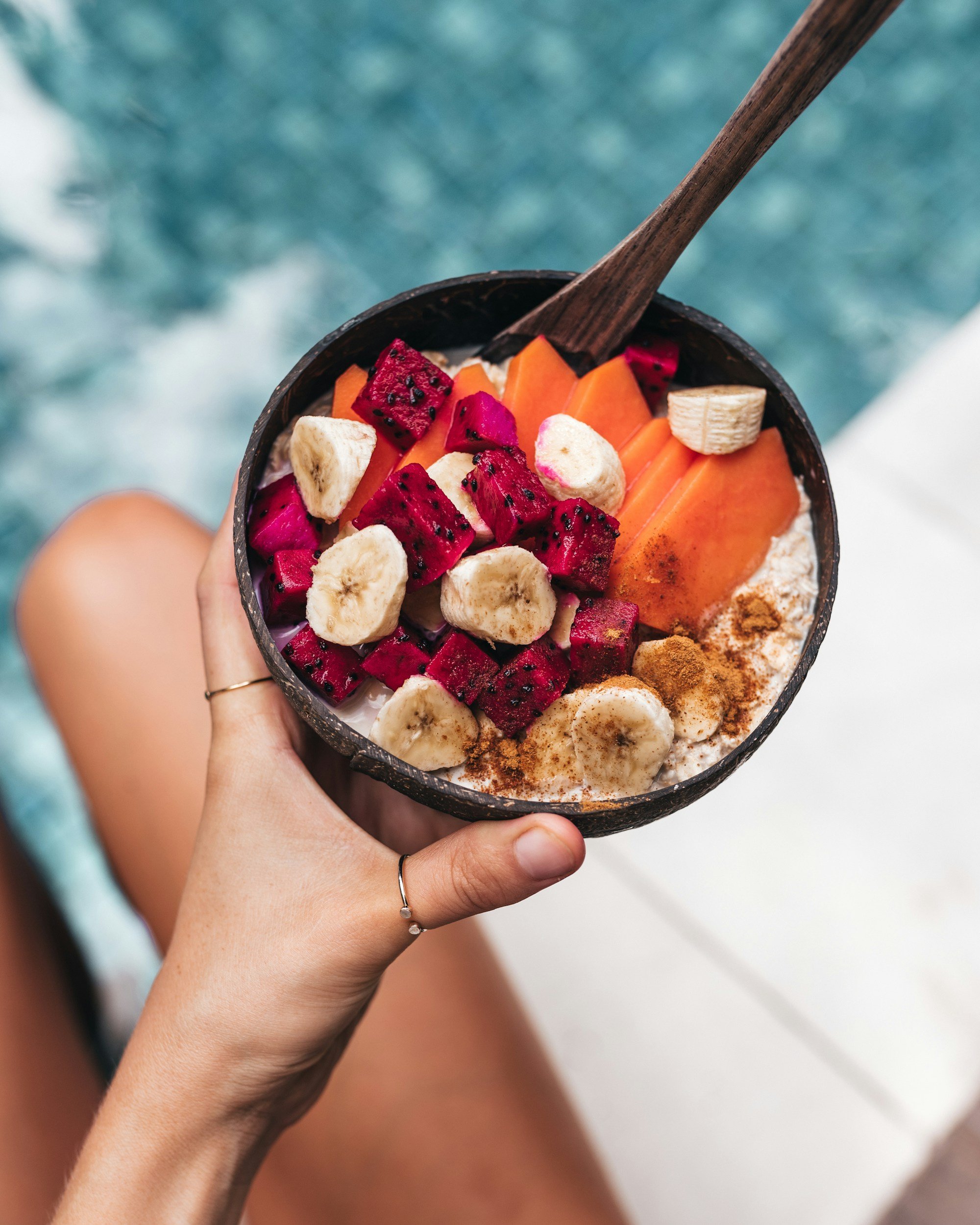 Colourful bowl of anti-inflammatory whole foods including dragon fruit, banana and papaya held in hands — representing the dietary approach to PCOS management. Emba Wellness Melbourne naturopath