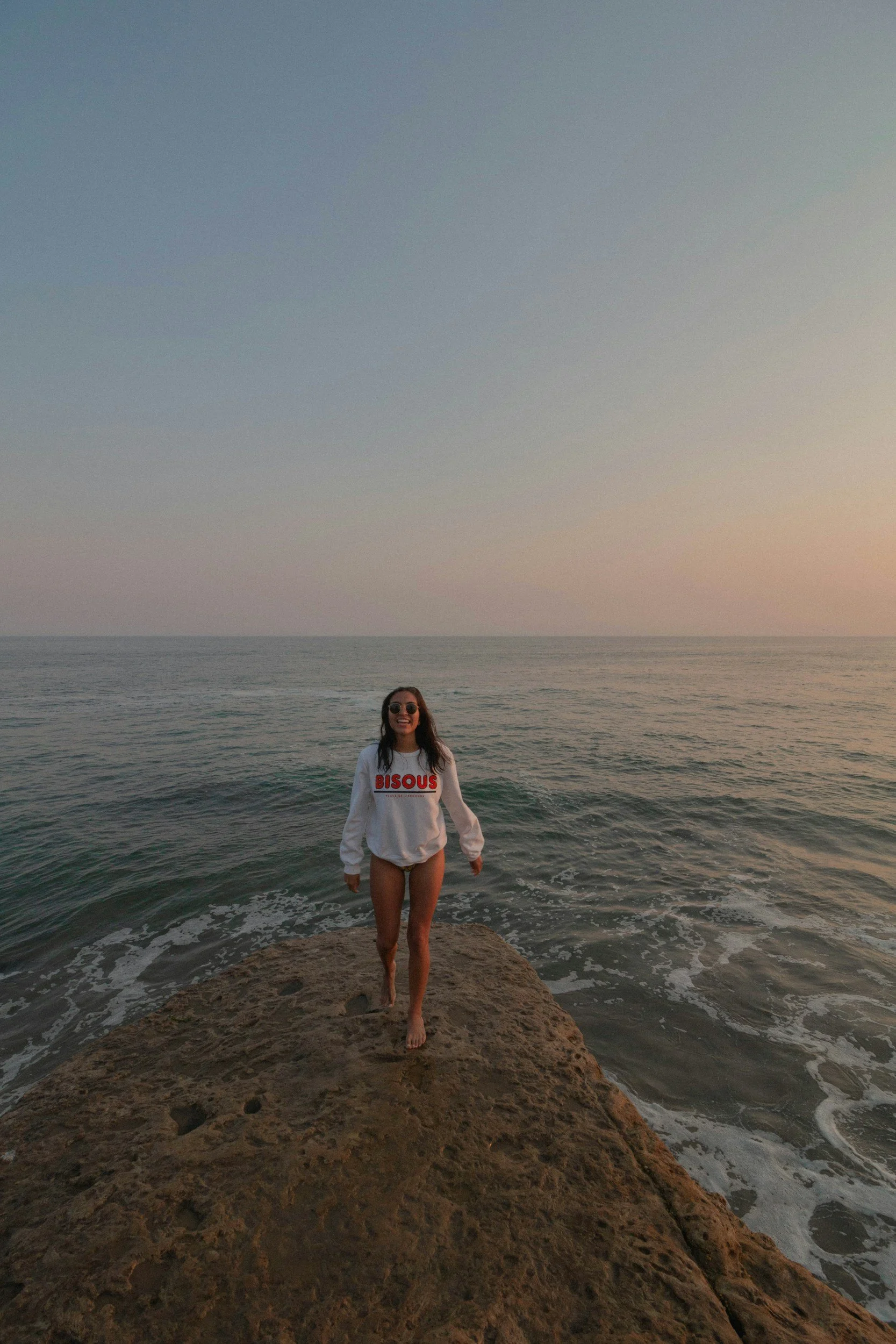 Woman standing barefoot on coastal rocks by the ocean — representing resilience and the journey to finding answers with PCOS. Emba Wellness Melbourne naturopath