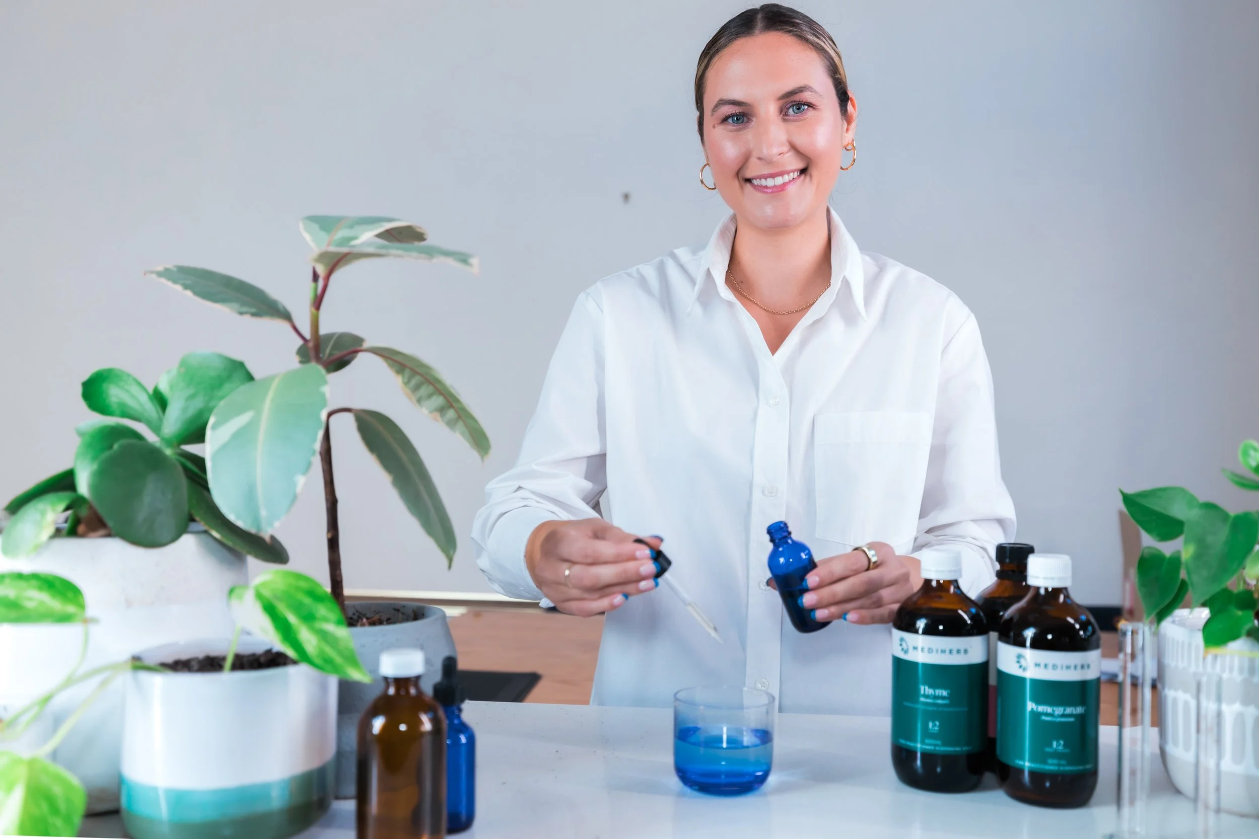 Jessica Diakoumakos, clinical naturopath and founder of Emba Wellness Melbourne, with practitioner-grade herbal medicine tinctures