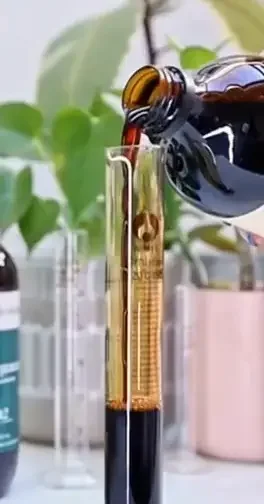 Naturopath Jessica Diakoumakos, pouring a herbal tincture into a glass measuring cylinder