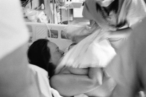 downtown toronto birth photographer captures mother catching baby during hospital birth at mount sinai