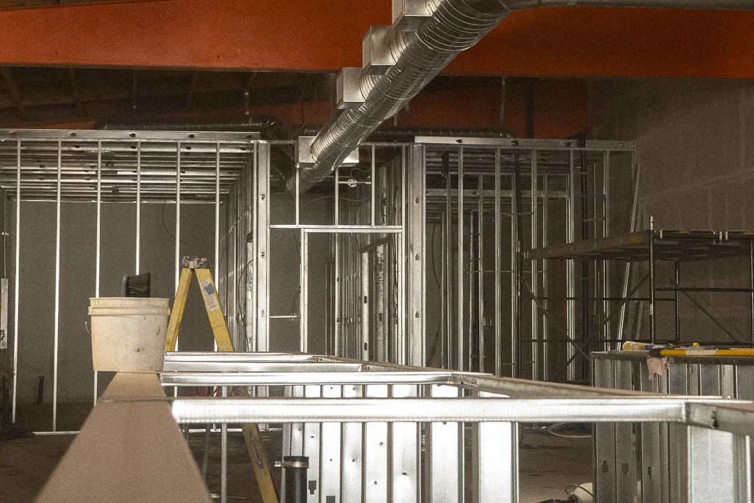 Saguaro Coffee Construction site with metal framing, a ladder, and ductwork in progress.