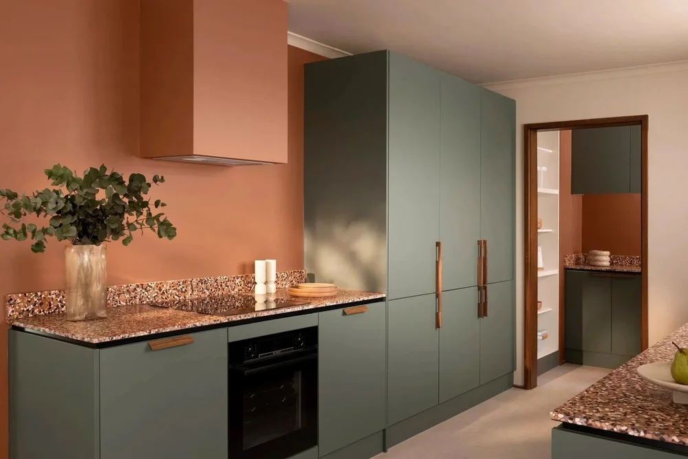 Gumtree House kitchen: terracotta wall and sage joinery