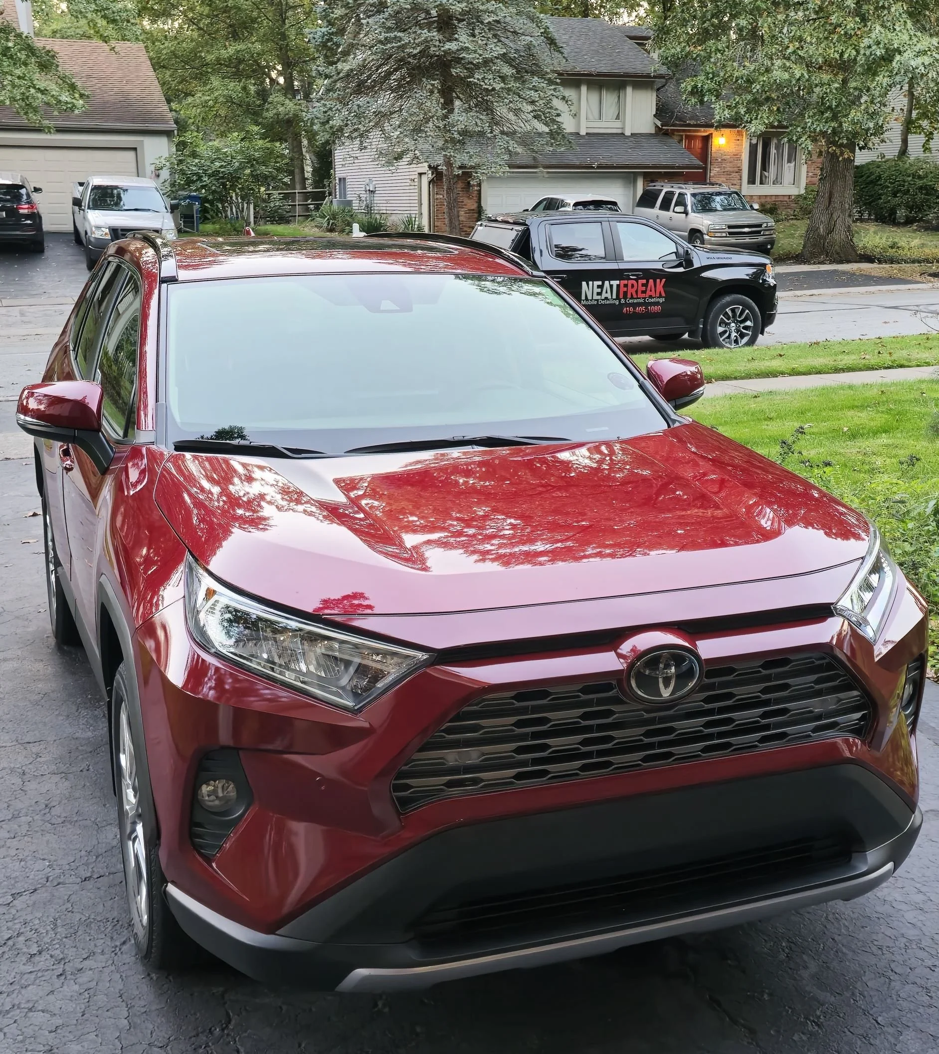 Shiny clean Toyota Rav4 in driveway with Neat Freak truck in background.