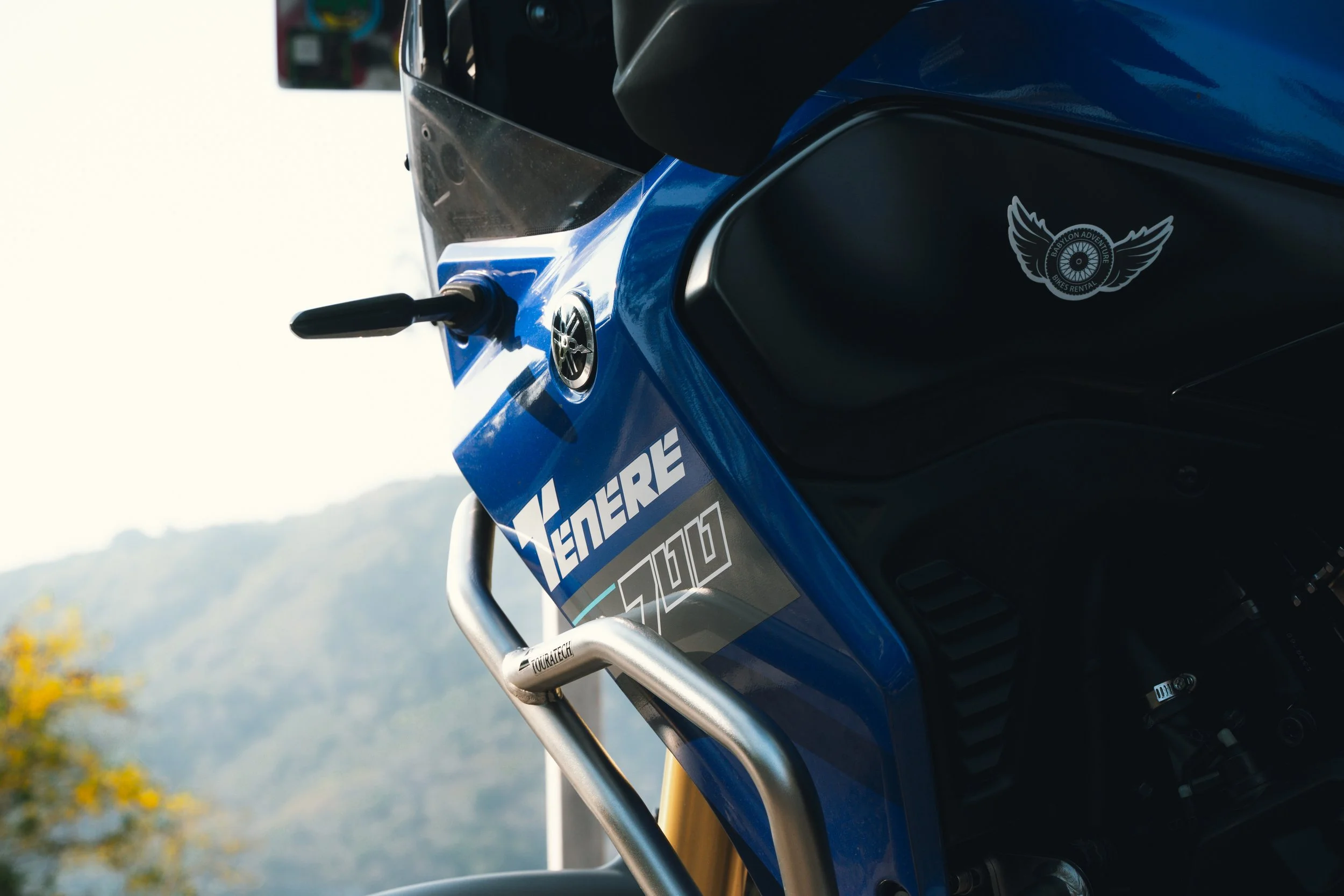 Close-up of a blue and black motorcycle with the brand name 'Vénère' and the model number 5100 on the side, featuring a sticker with a winged design.